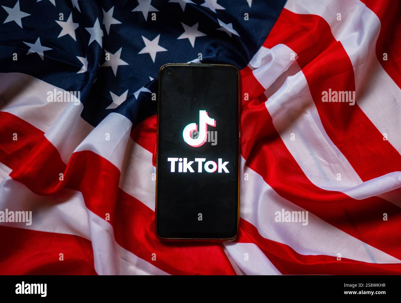 TikTok auf dem Bildschirm des Smartphones mit Hintergrund der USA-Flagge Stockfoto