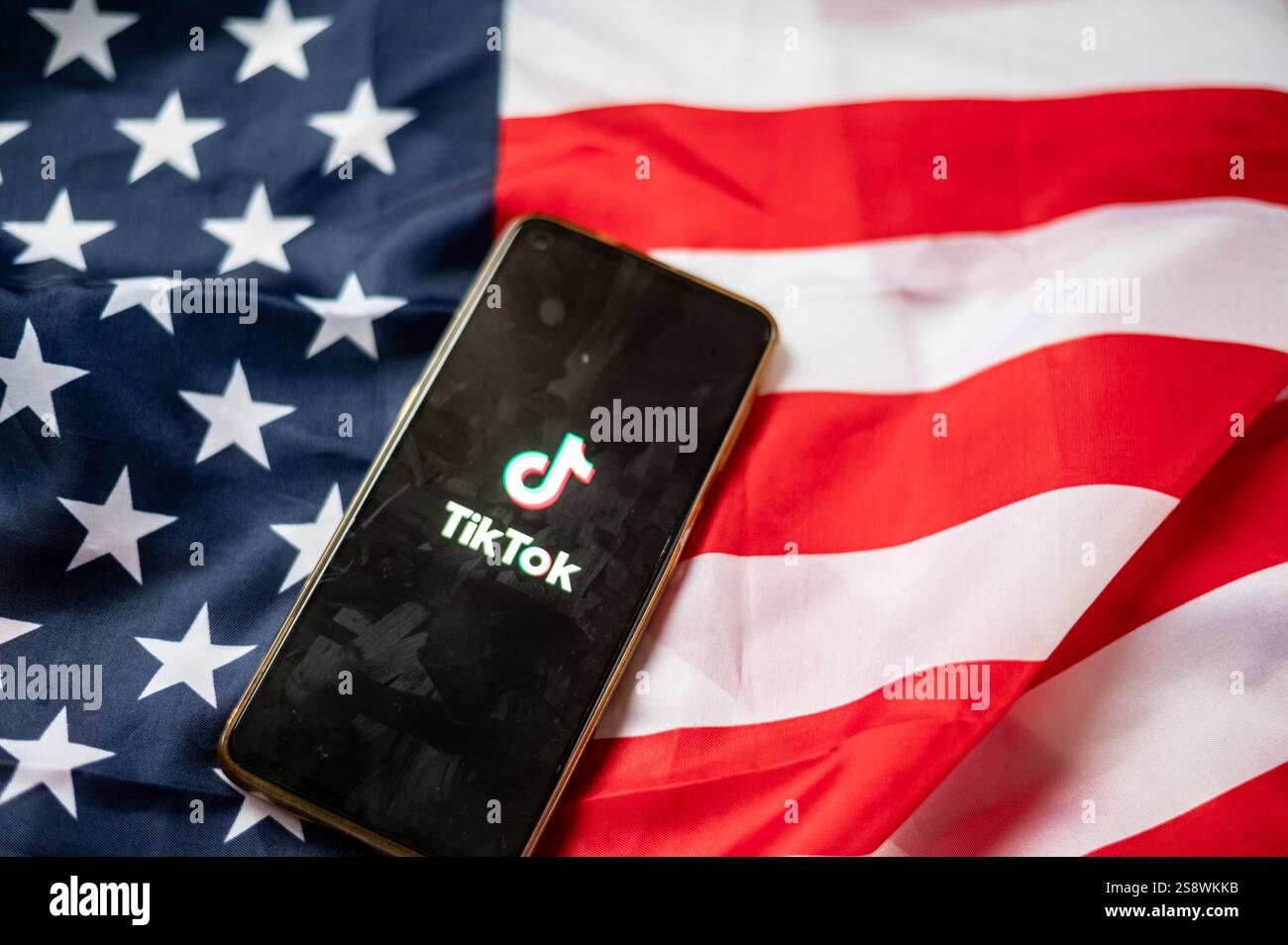 TikTok auf dem Bildschirm des Smartphones mit Hintergrund der USA-Flagge Stockfoto