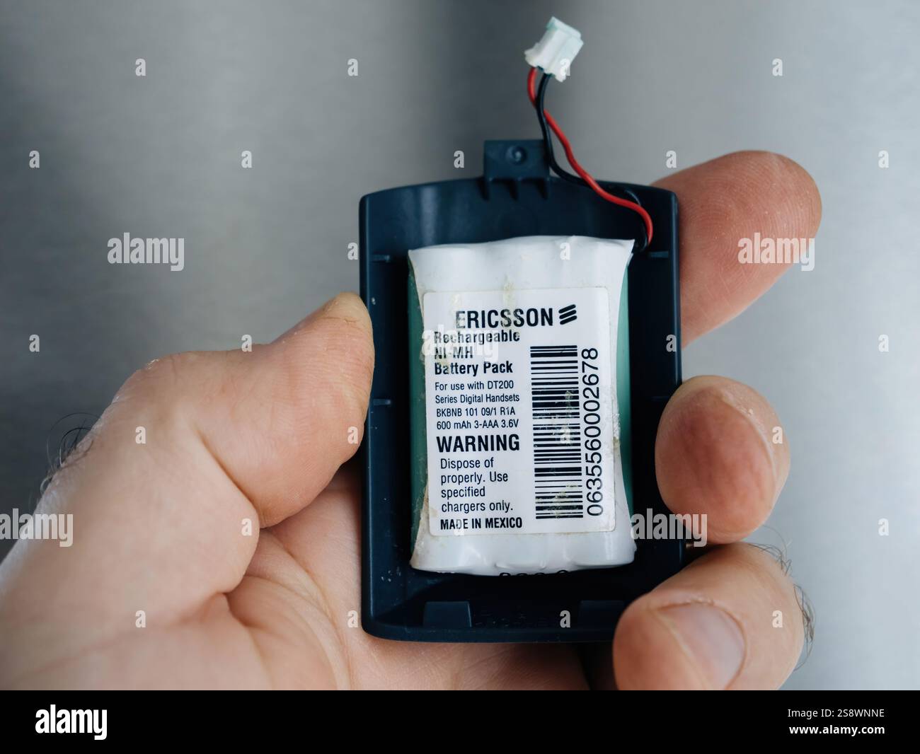 Paris, Frankreich - 25. April 2024: Ericsson Ni-MH-Akku sicher in einem schwarzen Schutzgehäuse platziert und mit sichtbarem Anschluss in der Hand gehalten Stockfoto