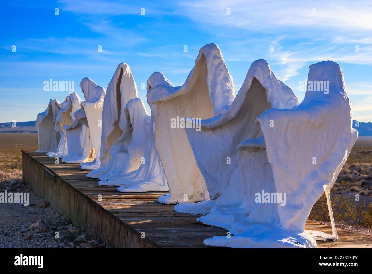 Eine Gruppe von weißen Gespensterstatuen ist mit Schnee bedeckt. Die Statuen sind in einer Reihe auf einer hölzernen Plattform angeordnet. Vorstellung von Geheimnis und Intrige als Th Stockfoto