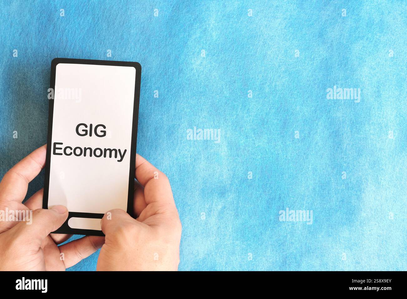 Menschliche Hand hält Handy mit geschriebenem Phrase Gig Economy. Gig Economy-Konzept. Stockfoto
