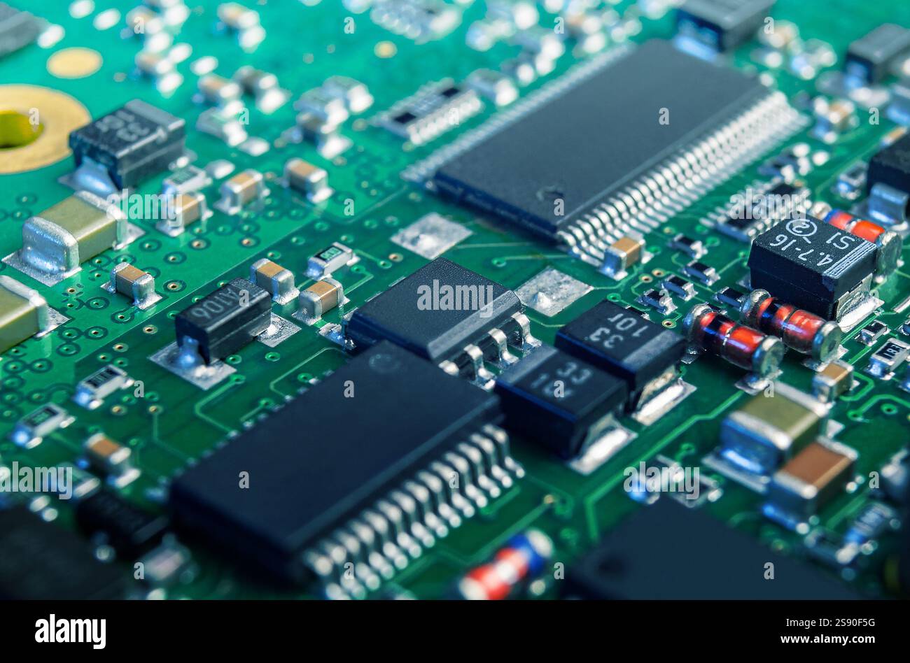 Eine komplizierte Ansicht einer elektronischen Leiterplatte, die verschiedene Komponenten, einschließlich Chips und Widerstände, anzeigt und deren komplexe Konstruktion unterstreicht. Stockfoto