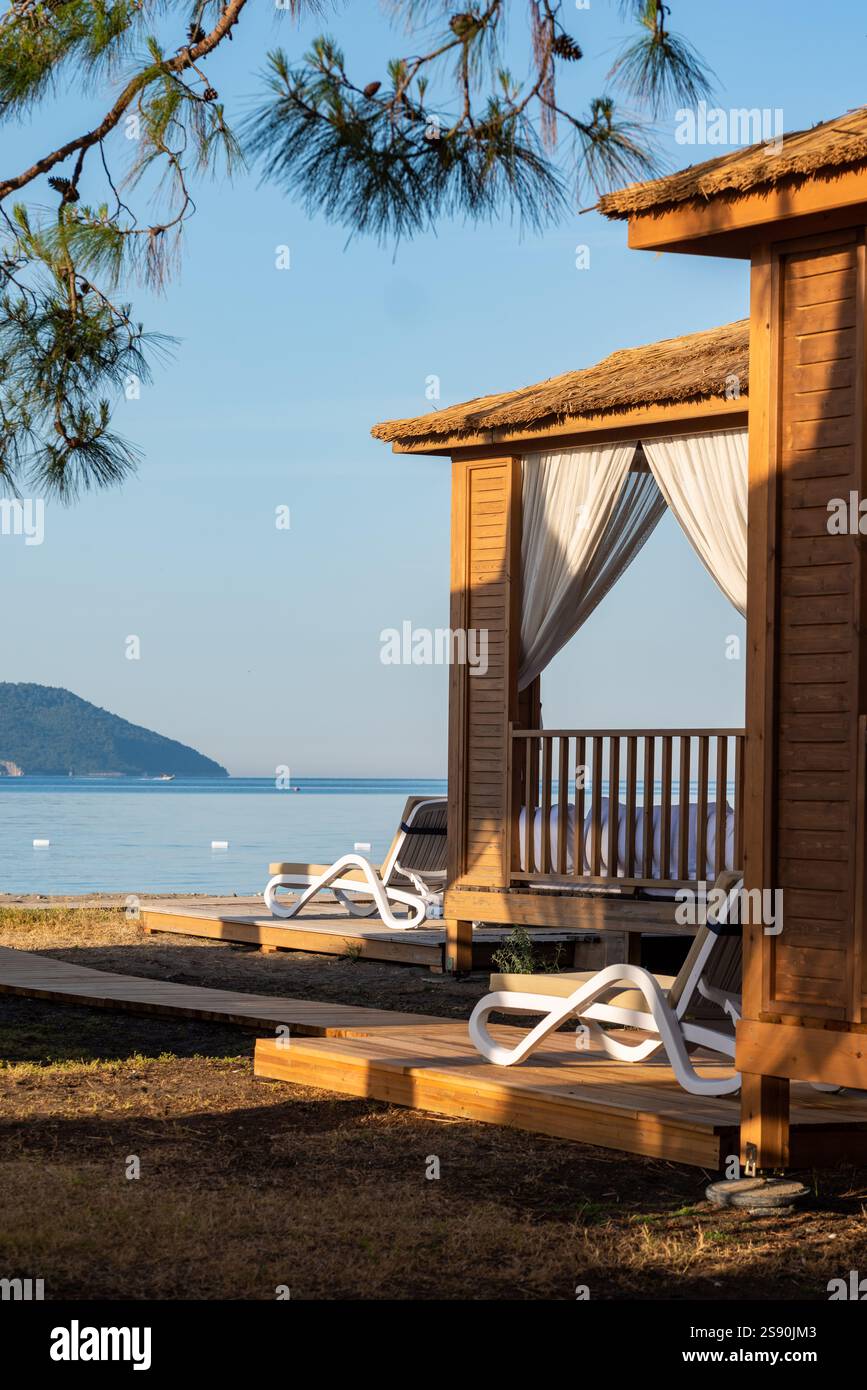 Private Strandhütten an einer ruhigen Sandküste bei Sonnenuntergang Stockfoto