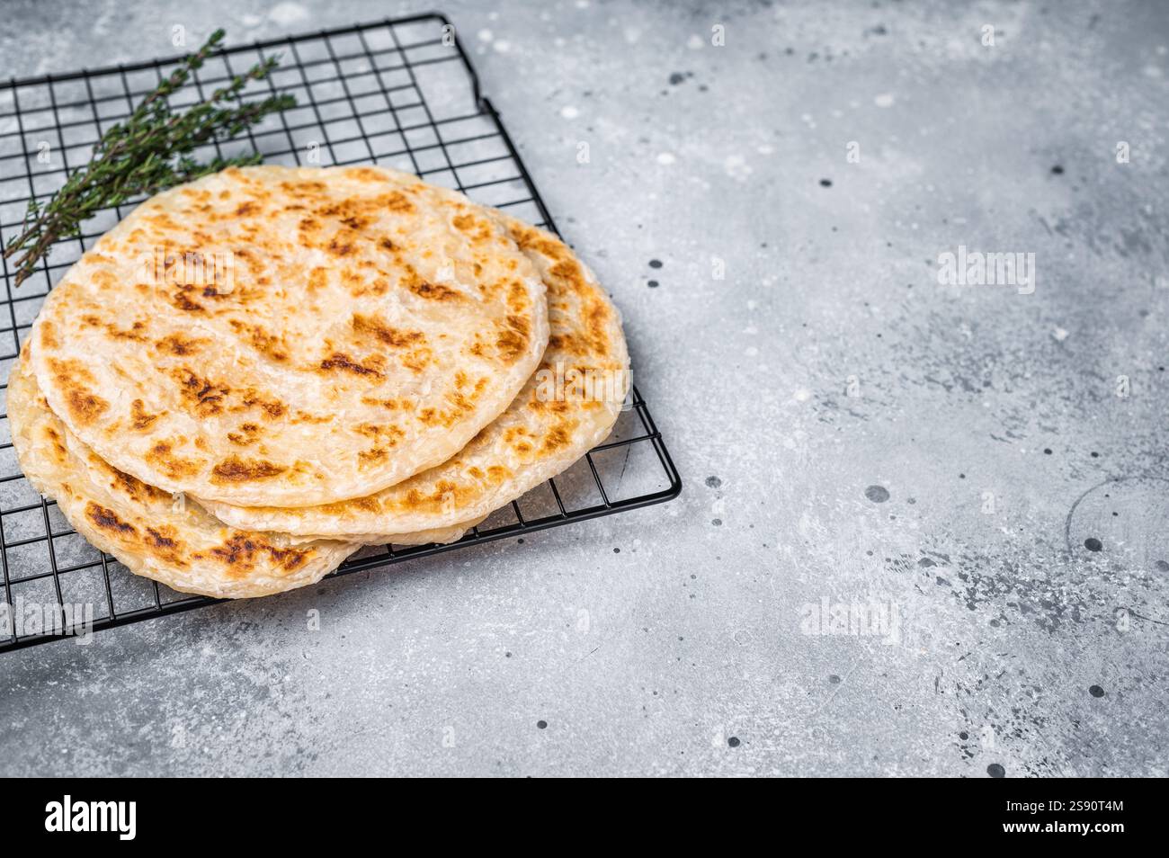 Hausgemachte Kerala-Weizen-Paratha, geschichtete Parotta. Grauer Hintergrund. Draufsicht. Stockfoto