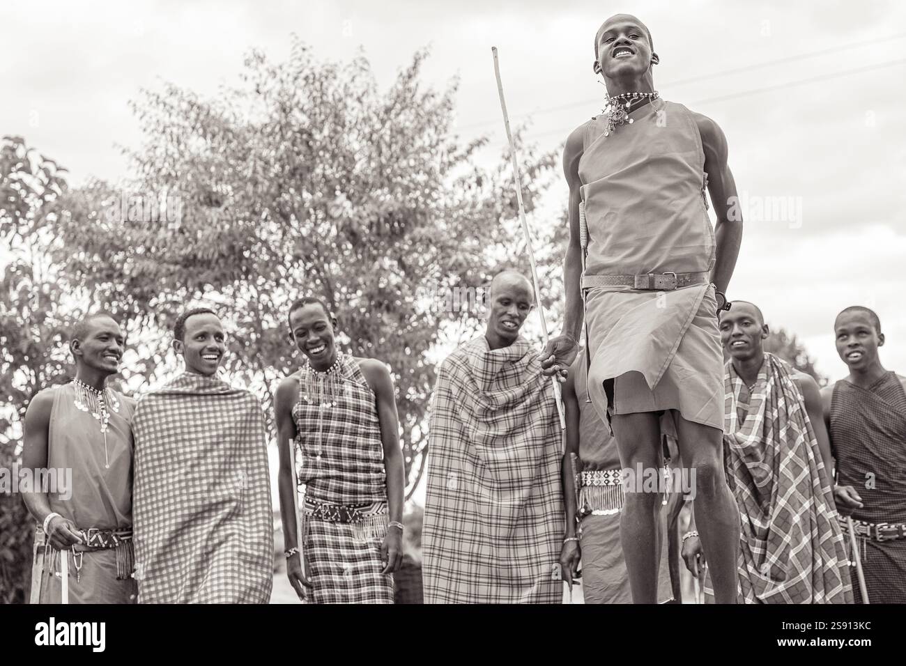 Gruppe von Maasai-Männern in traditionellem Tanz im Freien in Schwarz und weiß Stockfoto