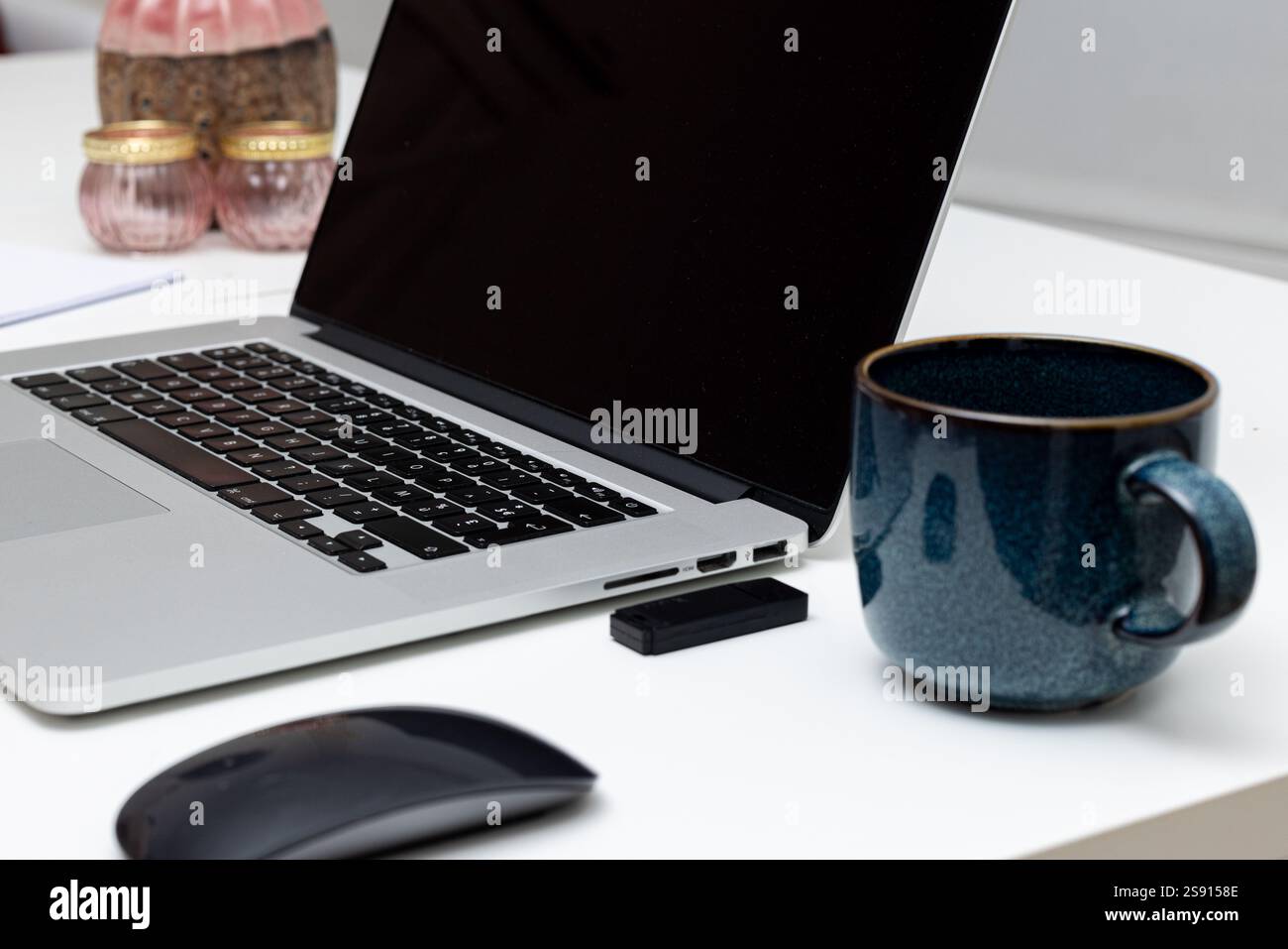 Laptop, Maus, USB-Stick und Kaffeetasse auf einem sauberen Schreibtisch Stockfoto