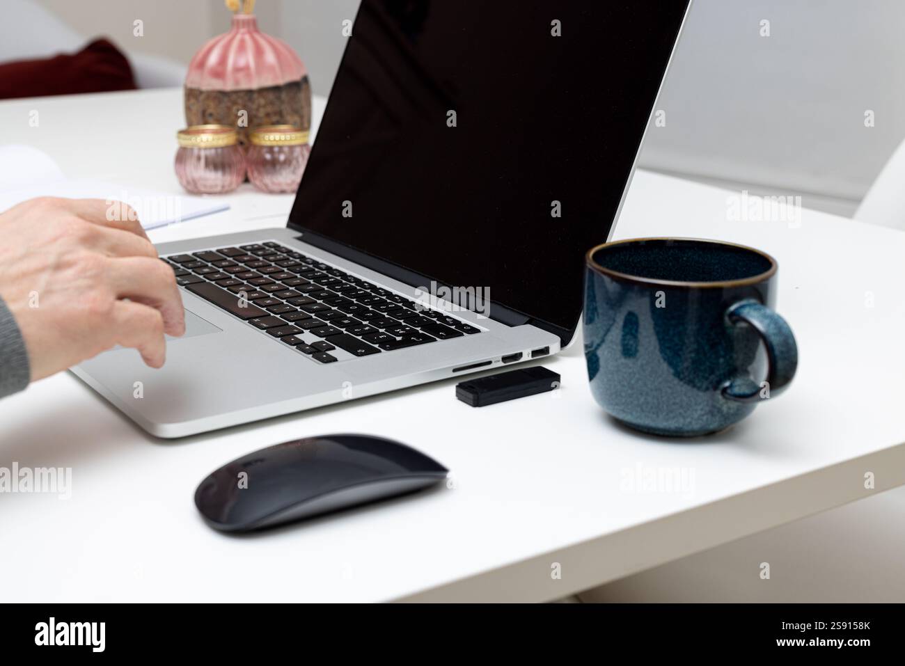 Arbeitsbereich mit Laptop, Maus und Kaffeetasse auf einem sauberen Schreibtisch Stockfoto