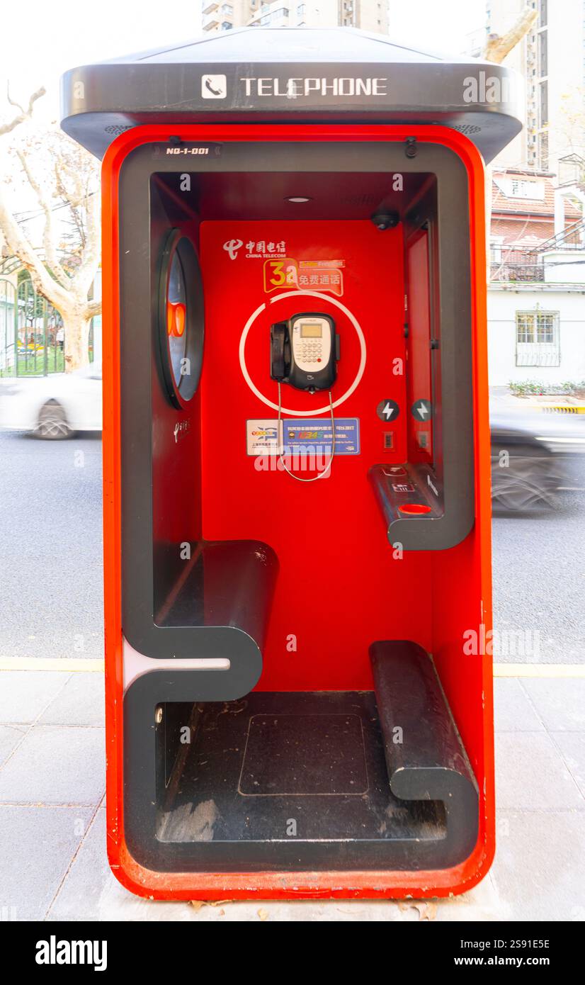Shanghai, China. Januar 2025. Die rote Telefonzelle auf einem Bürgersteig im Stadtzentrum Stockfoto