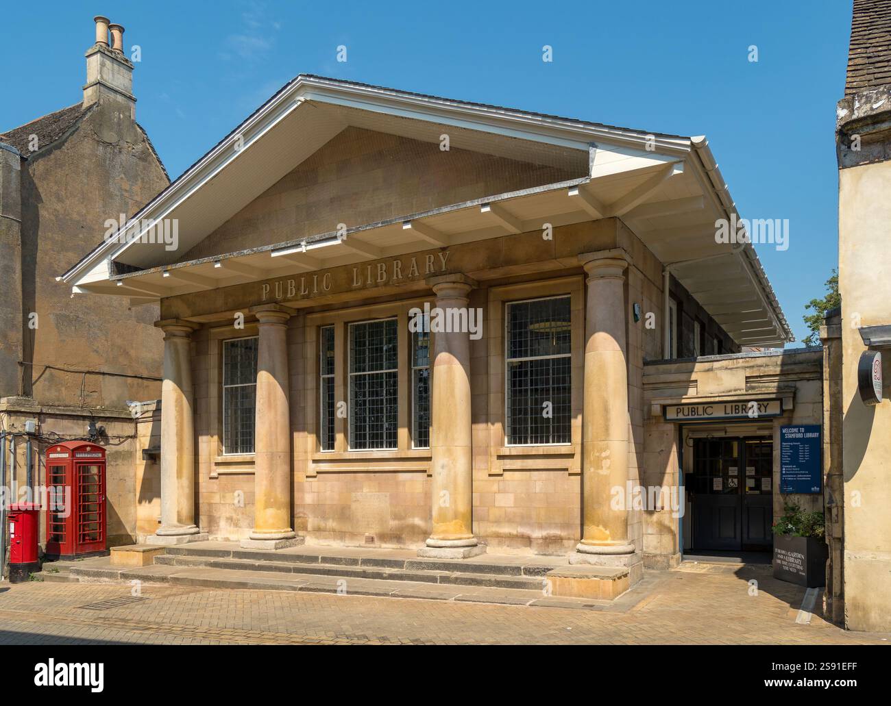 Die Vorderseite und der Eingang der Stamford Public Library. Ein Steingebäude in Quasten mit Säulengang und 4 toskanischen Steinsäulen und geformtem Giebel. Stockfoto
