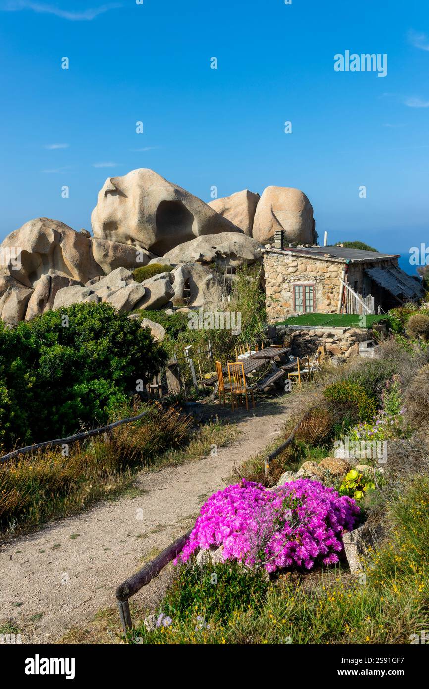 Kleines Haus in der Nähe großer Felsen an der mittelmeerküste in Capo Testa, Landschaft Sardiniens Stockfoto