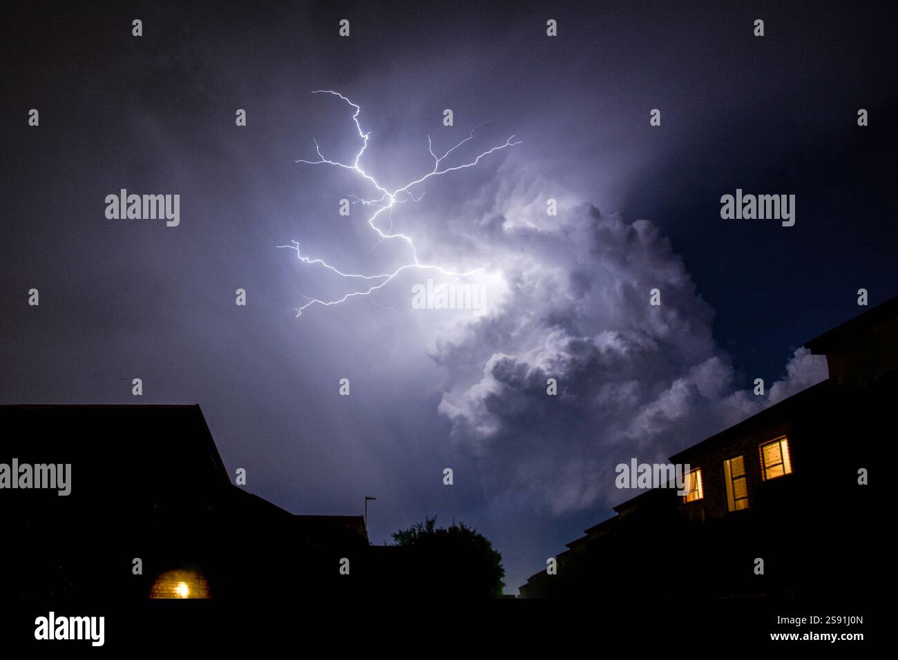 Wolke zu Wolke Blitz über der Silhouette von Häusern in der Stadt Stockfoto