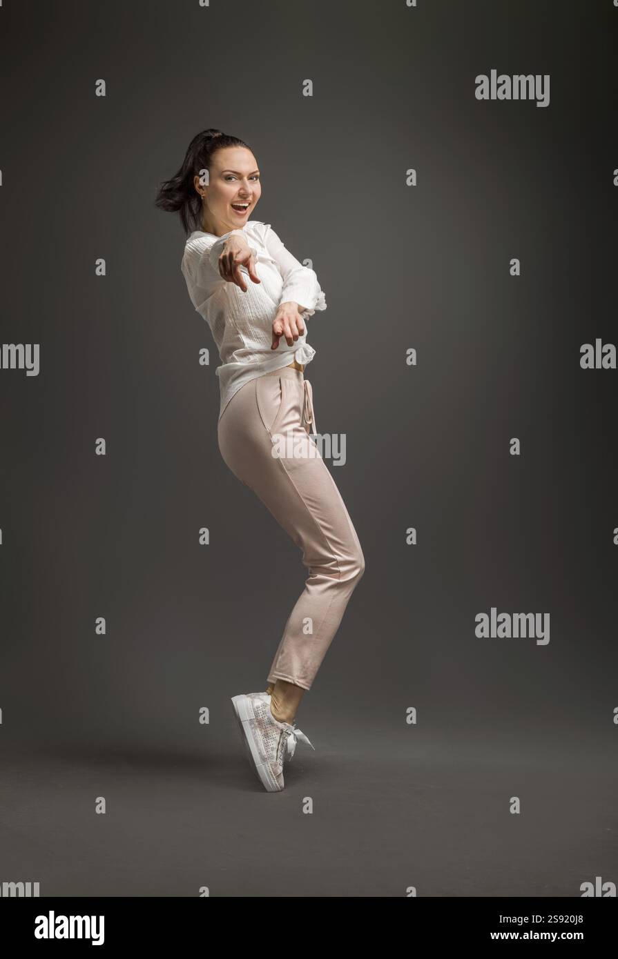 Junge und Schoene Taenzerin posiert im Studio vor farbigem Hintergrund Stockfoto