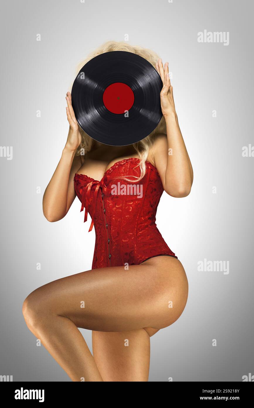 Schönes Pin-up-Modell mit Retro-Vinyl auf grauem Hintergrund Stockfoto