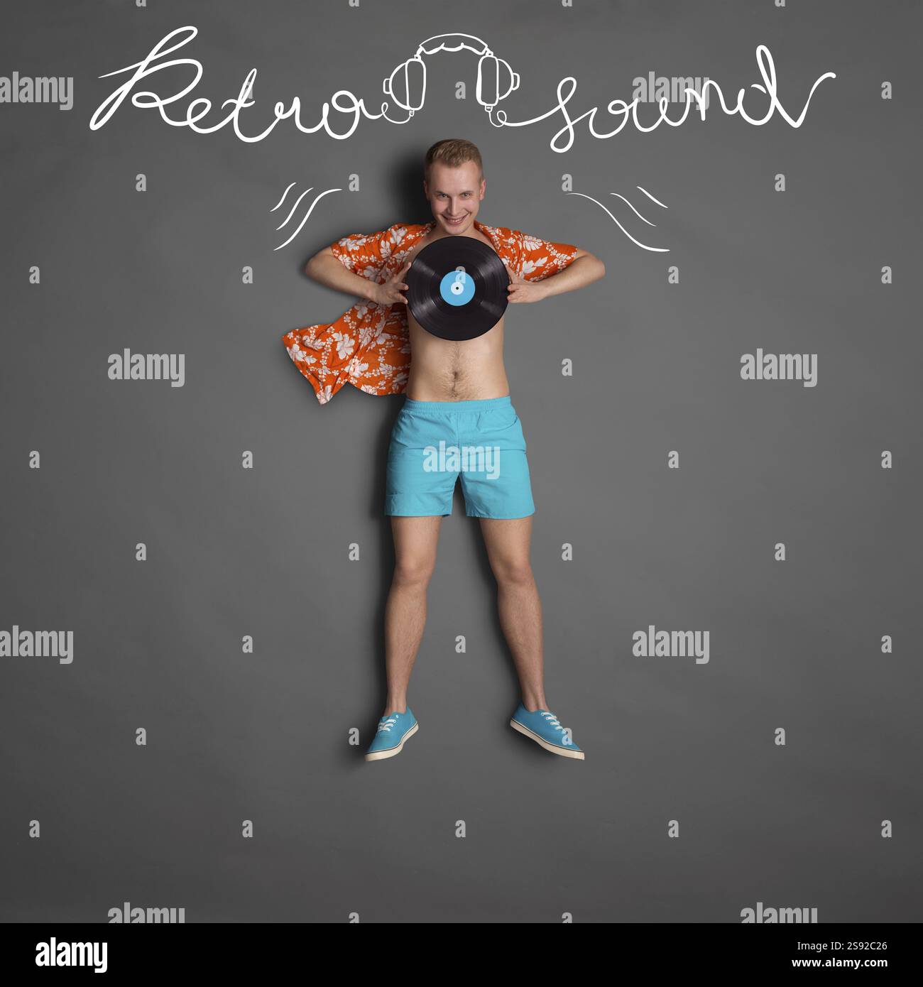 Draufsicht eines männlichen, modischen, hübschen Hipsters, der eine LP-Microgroove-Schallplatte vor einem Kreidehintergrund mit Text-Retro-Sound hält Stockfoto