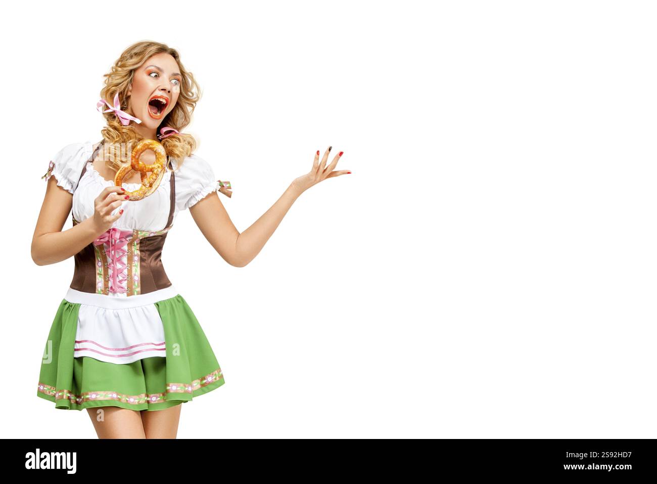 Kreatives Konzeptfoto der Oktoberfest-Kellnerin in traditioneller bayerischer Tracht mit Brezeln vor weißem Hintergrund Stockfoto