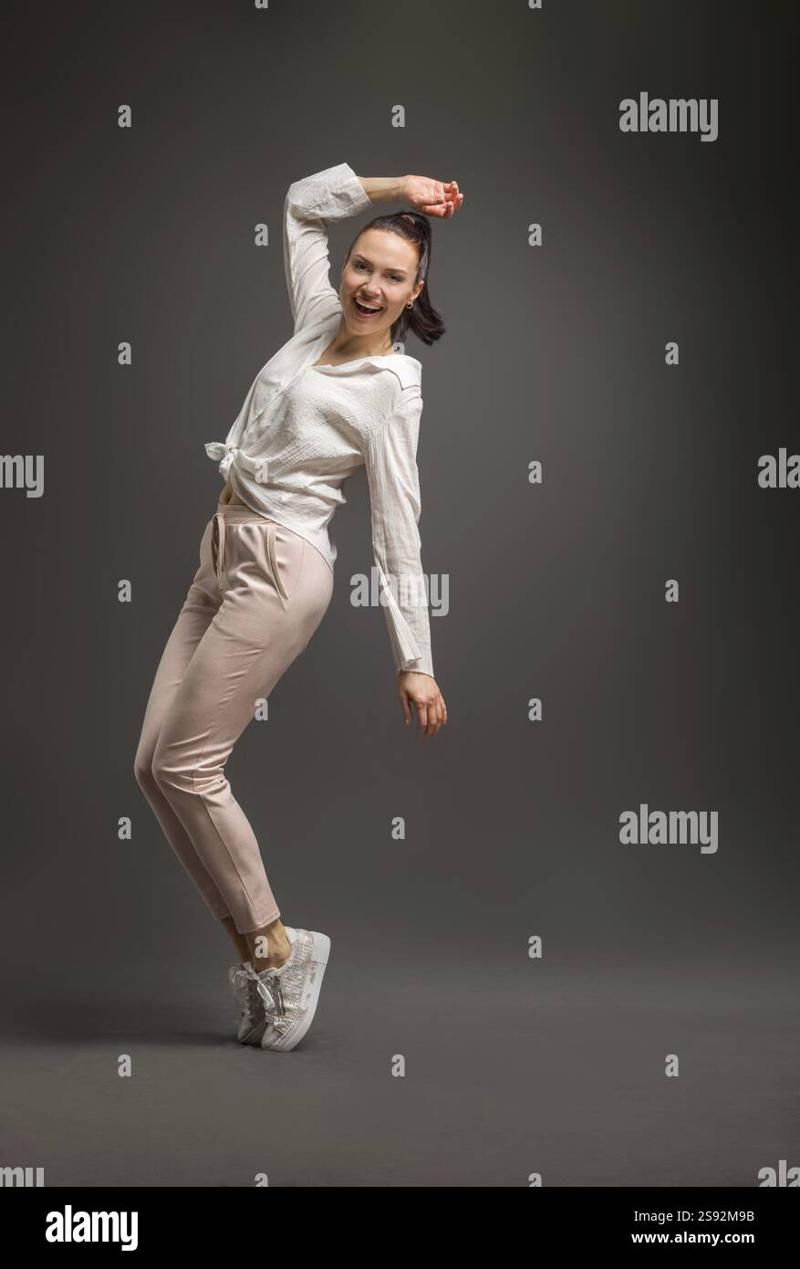 Junge und Schoene Taenzerin posiert im Studio vor farbigem Hintergrund Stockfoto