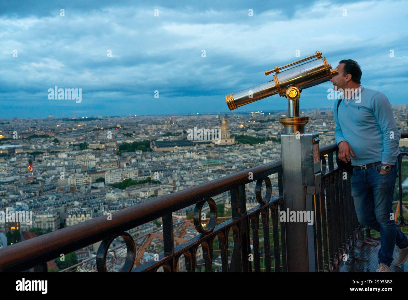 Paris, Frankreich - Touristen blicken nachts vom Eiffelturm über Paris, wenn die Gebäude beleuchtet werden. Stockfoto