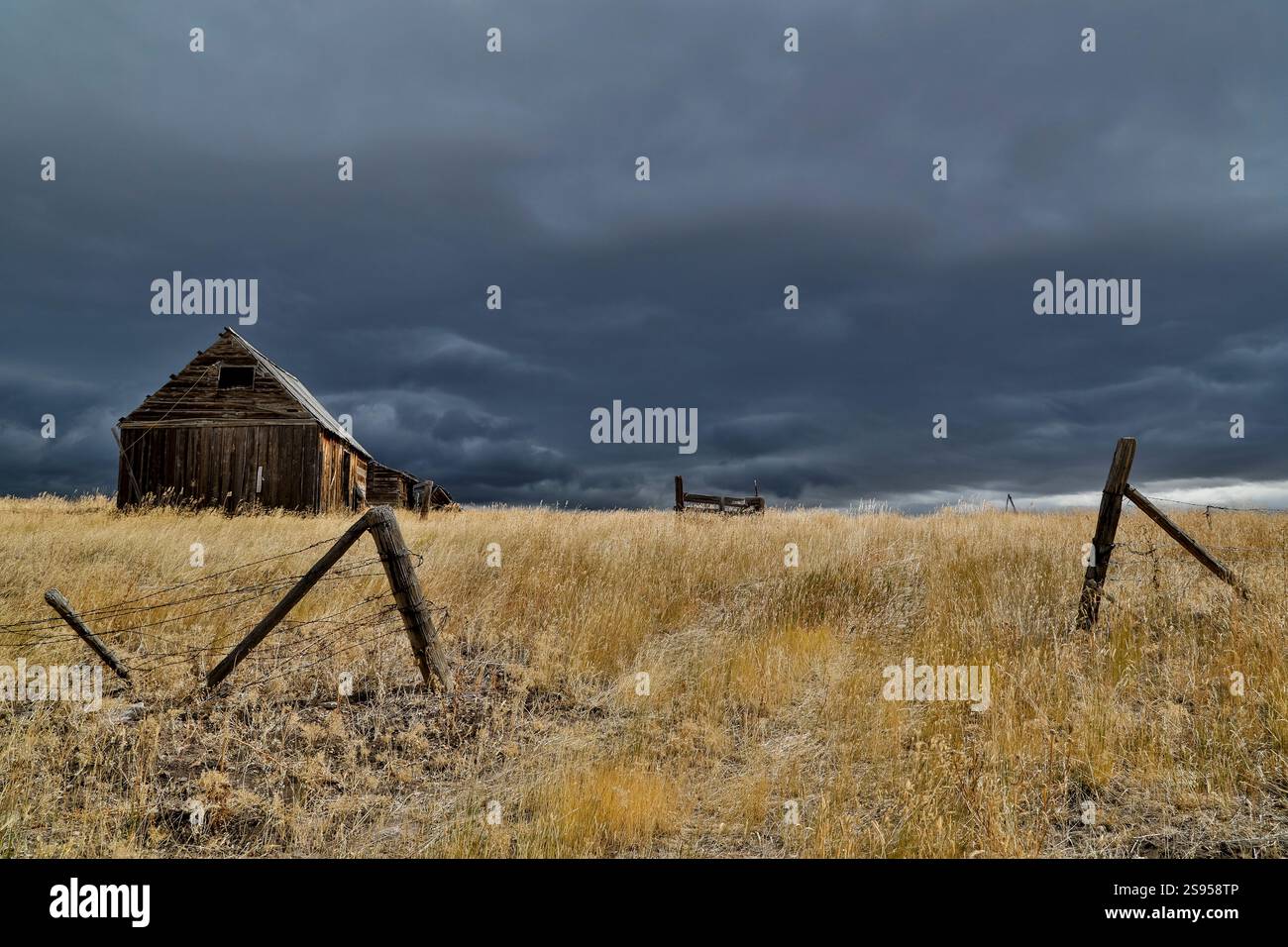 USA, Idaho, Liberty. Highway 36 mit vorbeiziehendem Sturm und alter Holzscheune Stockfoto