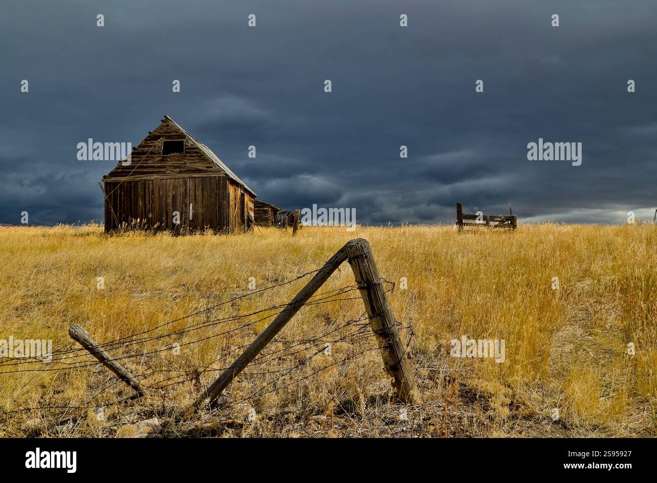 USA, Idaho, Liberty. Highway 36 mit vorbeiziehendem Sturm und alter Holzscheune Stockfoto