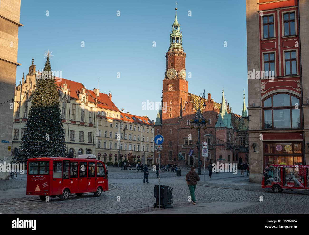 Breslauer Marktplatz im Januar mit einem Weihnachtsbaum, historischem Rathaus, farbenfrohen Gebäuden, festlicher Dekoration und Menschen, die auf Kopfsteinpflaster spazieren Stockfoto Breslauer Marktplatz im Januar mit einem Weihnachtsbaum, historischem Rathaus, farbenfrohen Gebäuden, festlicher Dekoration und Menschen, die auf Kopfsteinpflaster spazieren Stockfoto