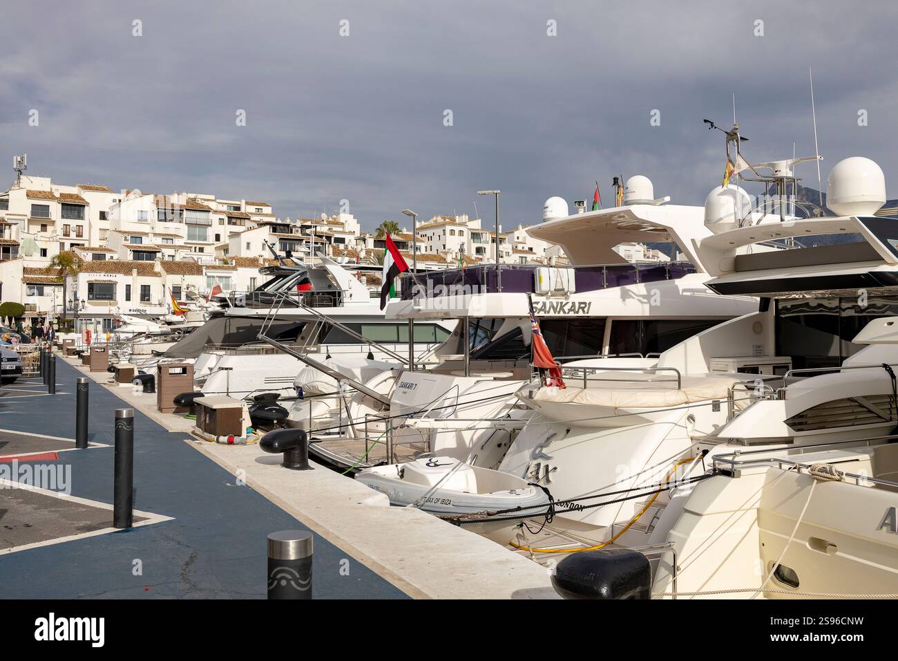 Luxus-Yachthafen mit Freizeitbooten mit typischen weißen Fassaden von Luxusmarkengeschäften und Restaurants im Hintergrund Stockfoto
