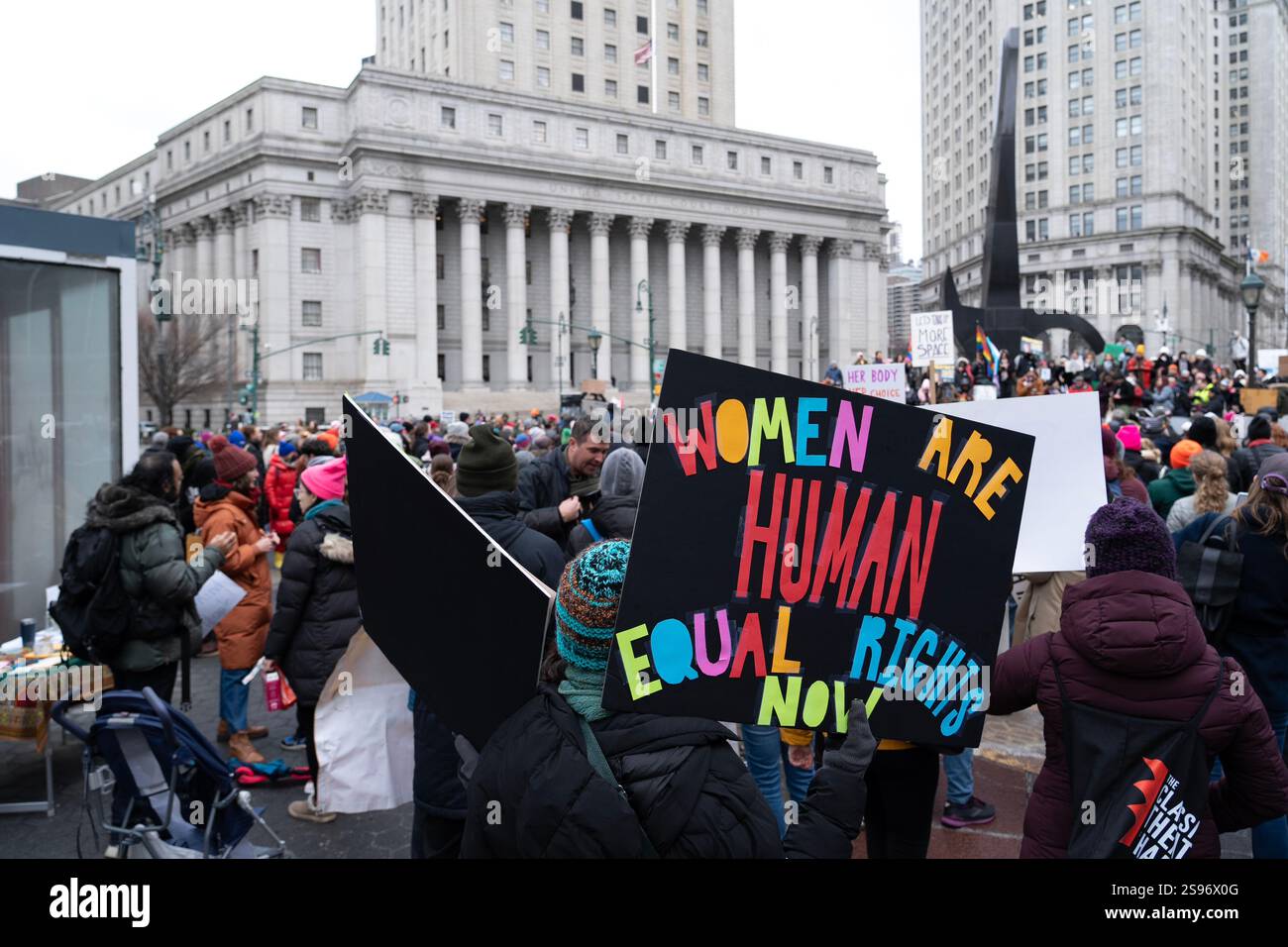 Gerade einmal 1.000 Menschen versammelten sich in Lower Manhattan im Rahmen des umbenannten Frauenmarsches, der jetzt als "Volksmarsch" bezeichnet wird, um gegen die Amtseinführung des designierten Präsidenten Donald Trump zu protestieren – ein weit entfernter Schrei von den geschätzten 200.000, die 2017 für die historische Kundgebung nach Midtown strömten. Am Foley Square, New York City. Demonstranten sprechen sich gegen viele der neuen amerikanischen Politik von Präsident Trumps aus. Stockfoto