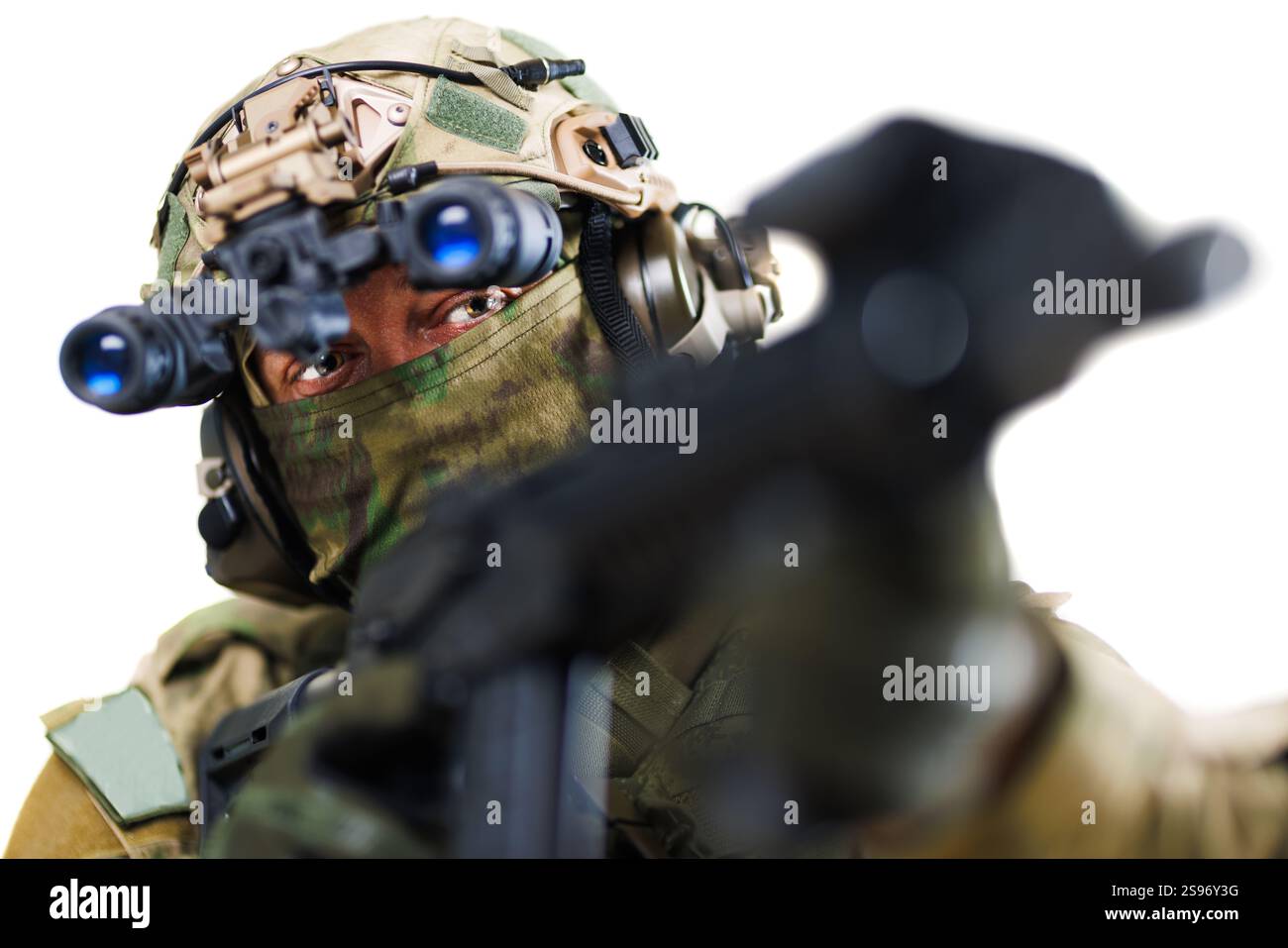 Ein spezieller Soldat der Spezialkräfte, ausgestattet mit fortschrittlicher taktischer Ausrüstung, einschließlich Nachtsichtbrille, zielt auf seine Waffe. Der Hintergrund ist isoliert Stockfoto