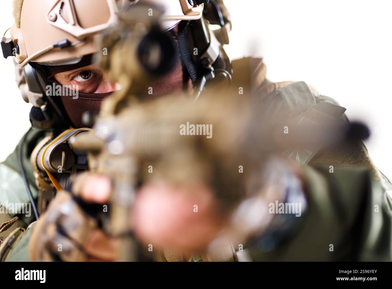 Ein taktischer Bediener zielt seine Waffe während einer Mission ab, wobei er intensive Fokussierung und professionelle Ausrüstung bietet. Zu den Highlights gehören detaillierte Ausrüstung und ein Bistro Stockfoto