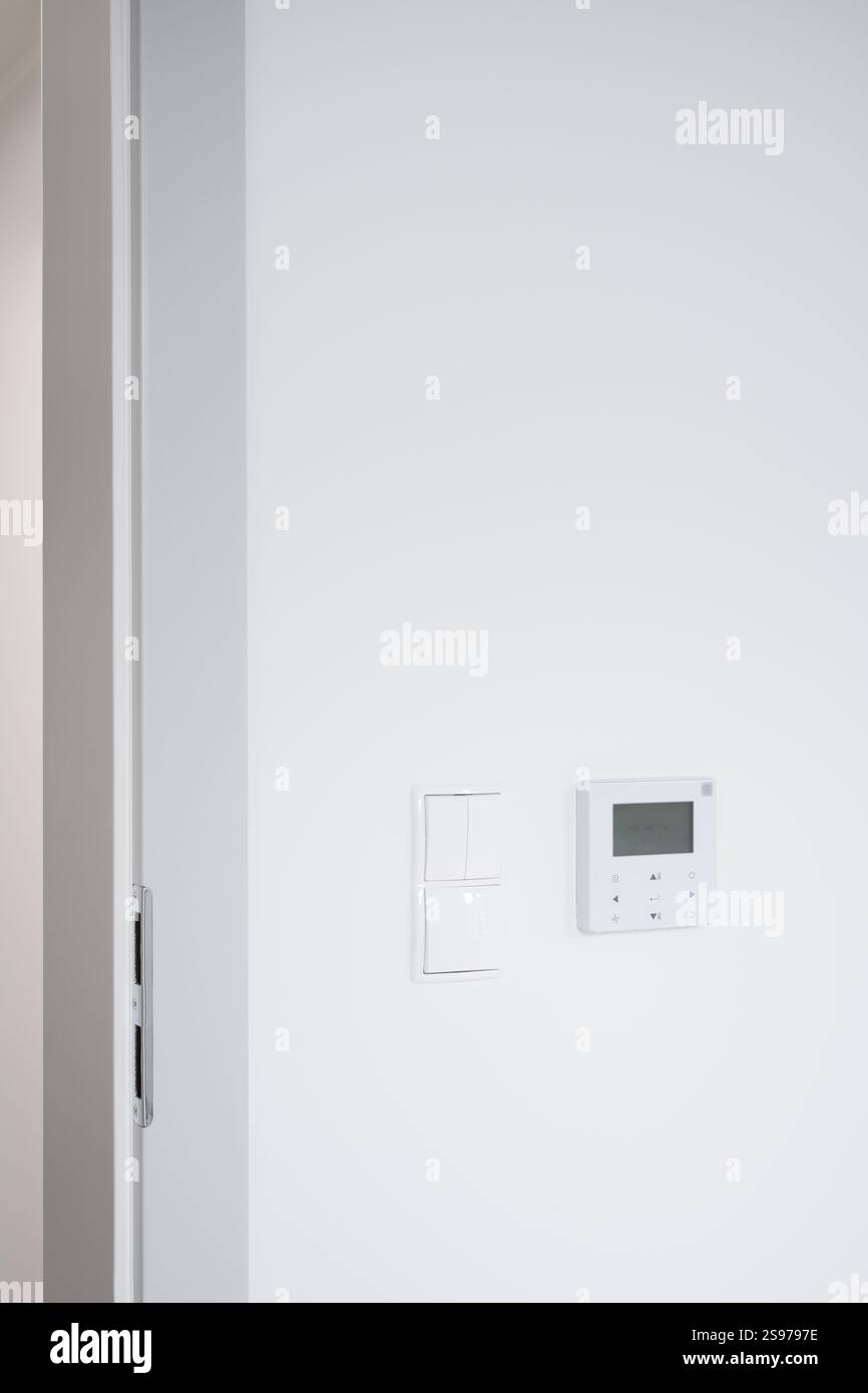 Moderner Türrahmen mit Lichtschalter und Bedienfeld Stockfoto
