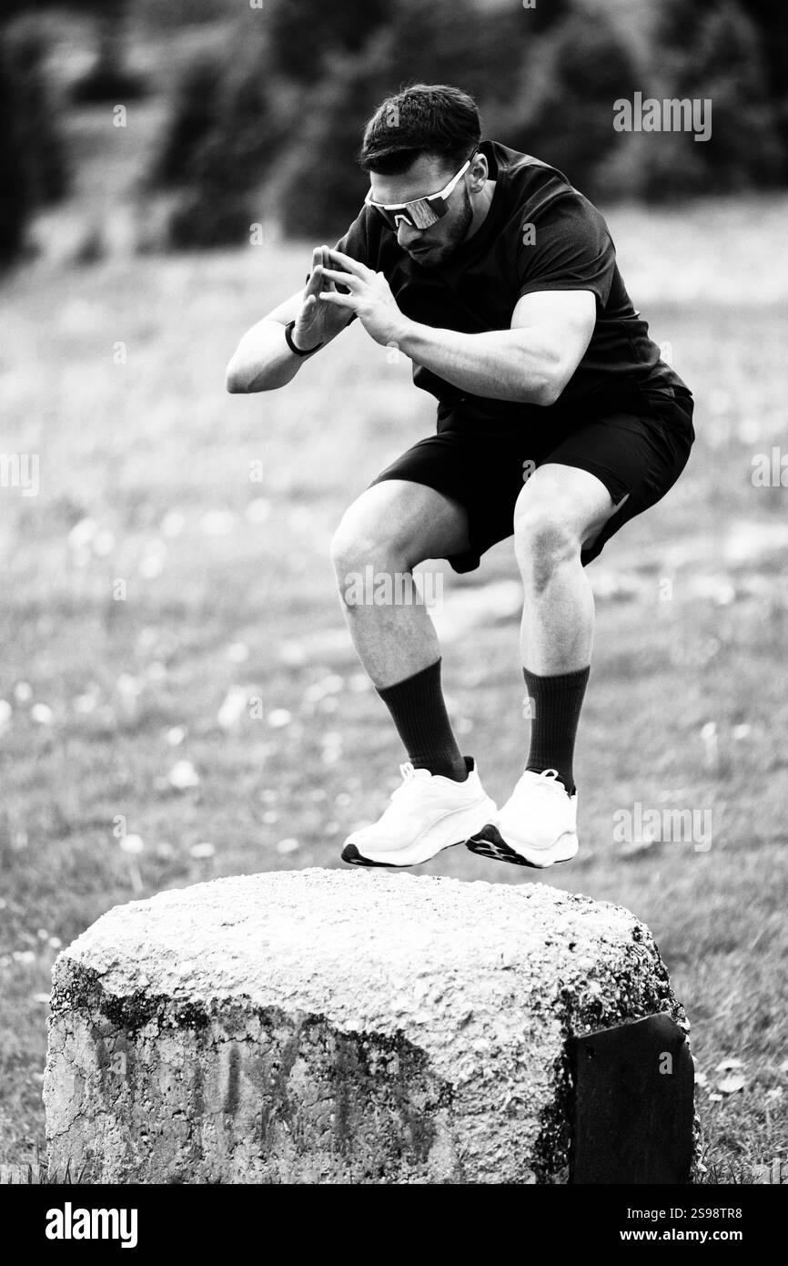 Athlet Using A Large Rock for Jump Exercises – Kombination von Fitness und Natur in Einer malerischen Umgebung im Freien Stockfoto