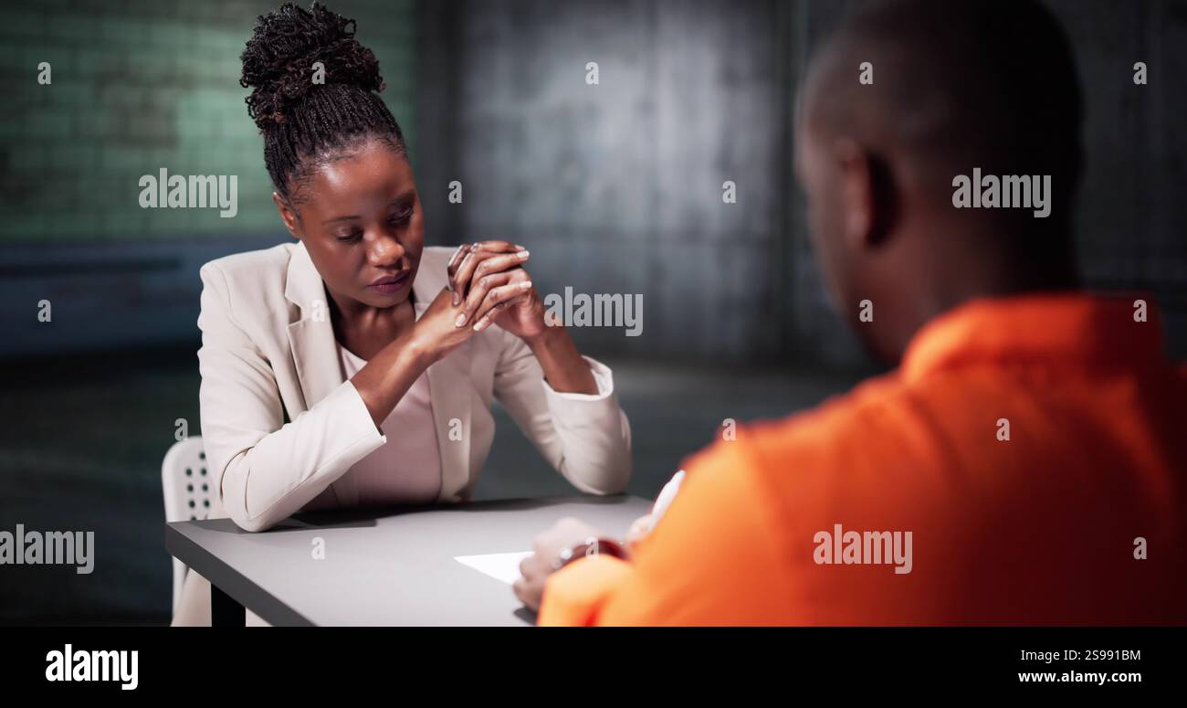 Ein Mann Unterschreibt Ein Schuldbekenntnis Im Gefängnis. Polizeiermittler Im Verhörraum Stockfoto