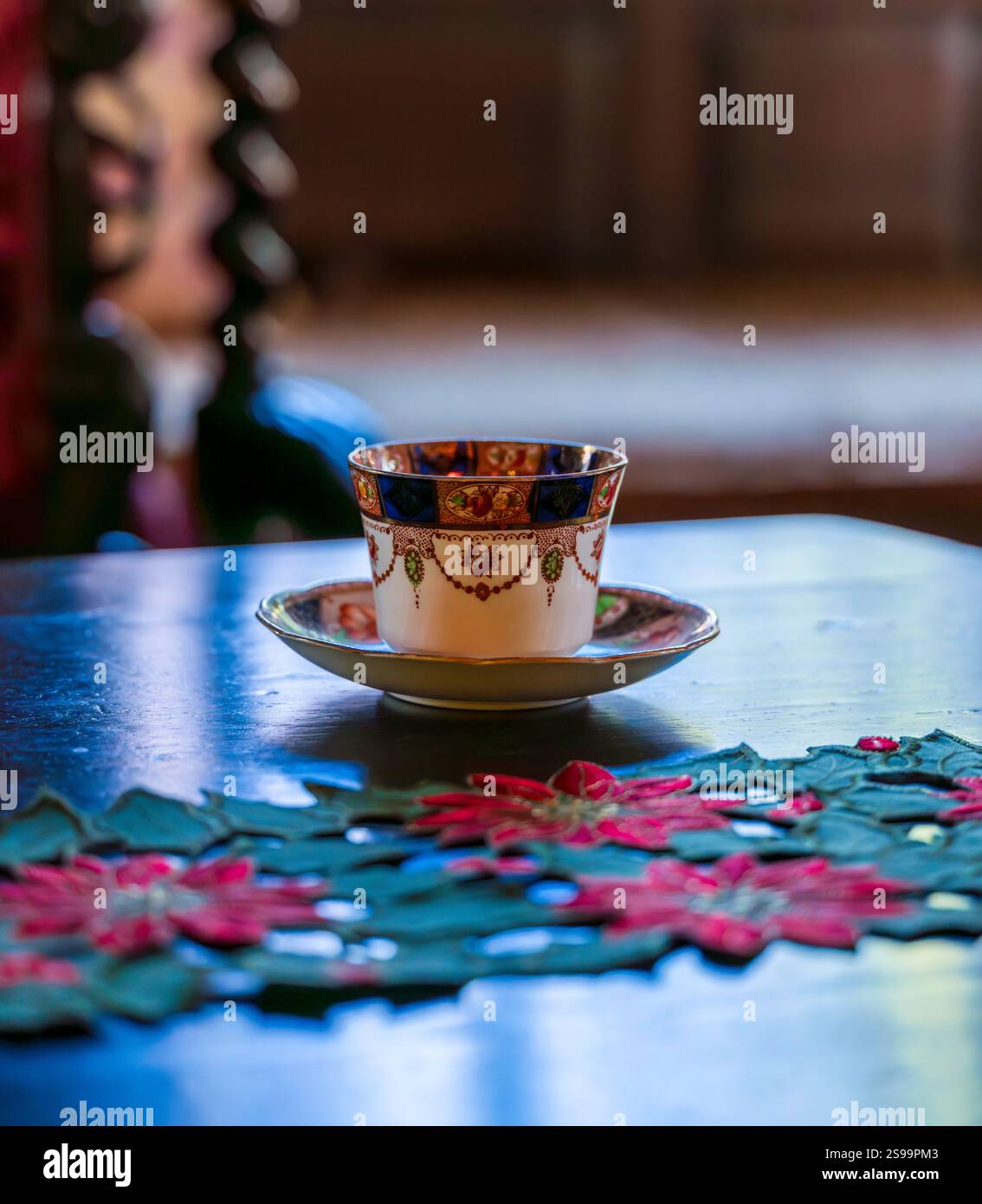 Elegante Vintage-Teetasse auf Holztisch mit Weihnachtsdekor in gemütlicher Inneneinrichtung Stockfoto
