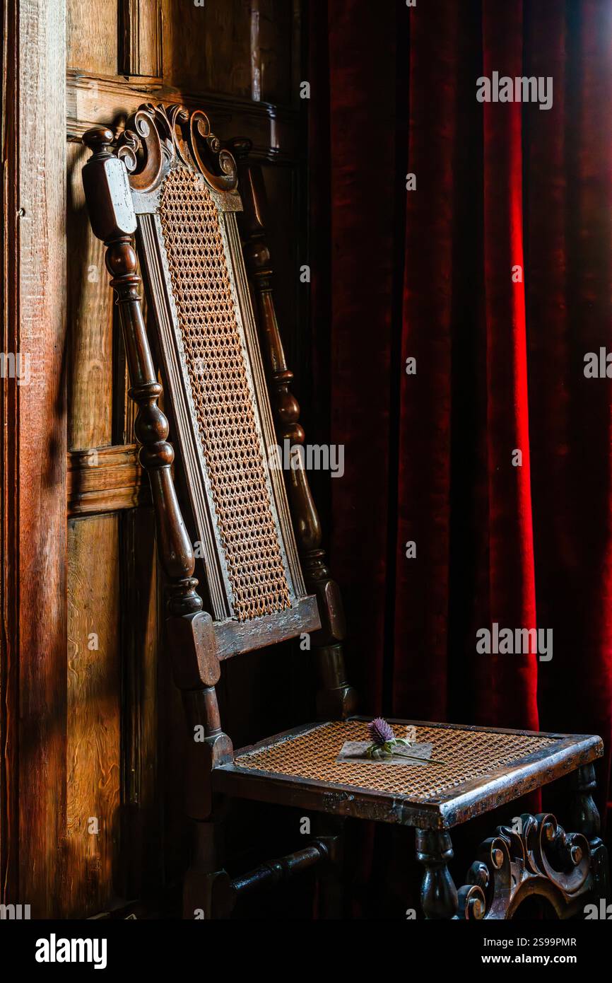 Antiker Holzstuhl mit Cane Weave Design und einer Histle in luxuriösem Vintage-Ambiente Stockfoto