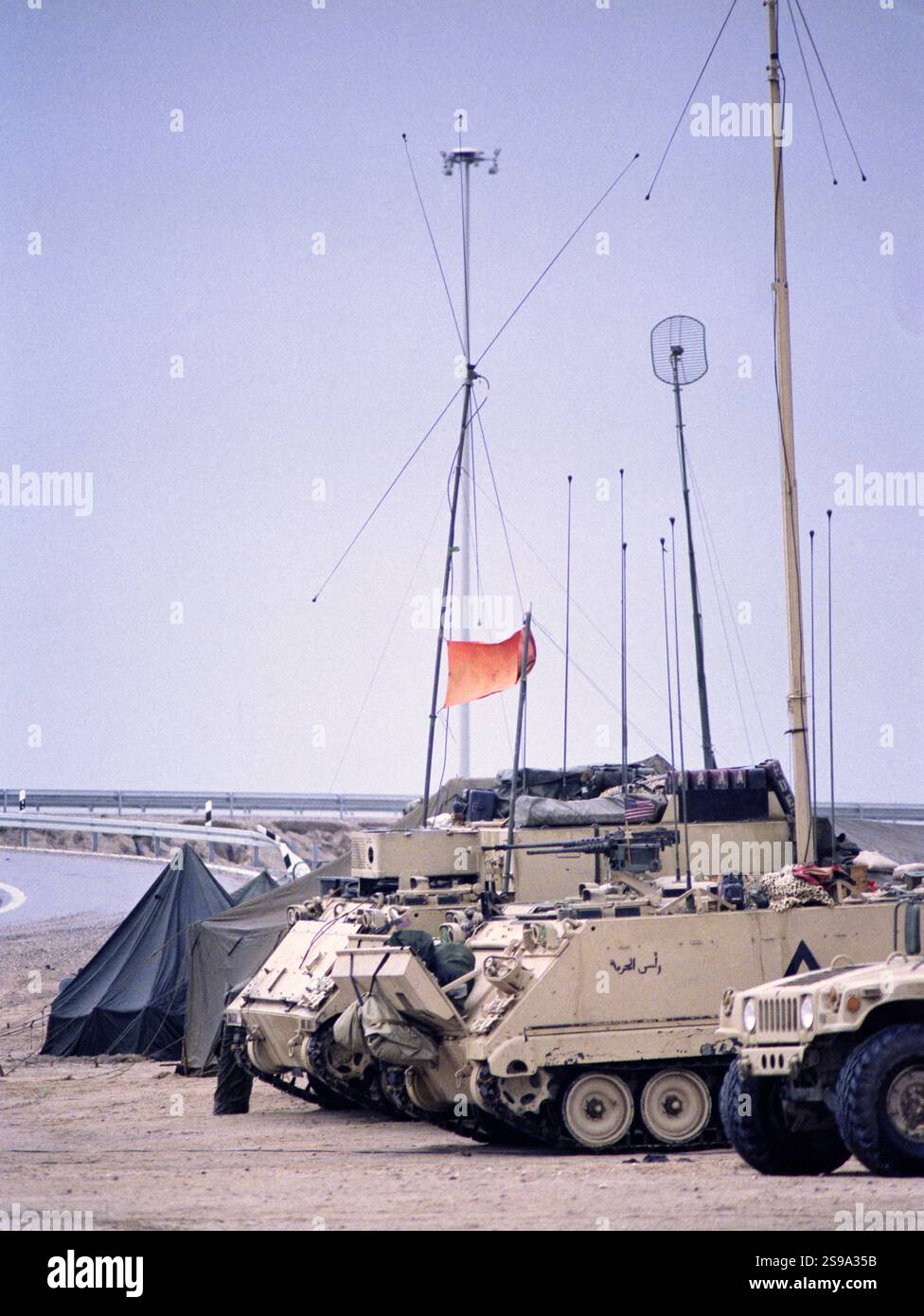 Erster Golfkrieg: 23. März 1991 Mittelwellen-Antenne und Antennen entspringen von M113 gepanzerten Personals-Trägern der 3. Panzerdivision der US Army. Diese Kommunikationsanlage befand sich neben dem Highway 8, wo sie den Highway 1 bei Safwan im südlichen Irak überquert, nur wenige Kilometer vom Flugplatz entfernt, wo der Waffenstillstand unterzeichnet wurde, um die Operation Desert Storm offiziell auszusetzen. Stockfoto