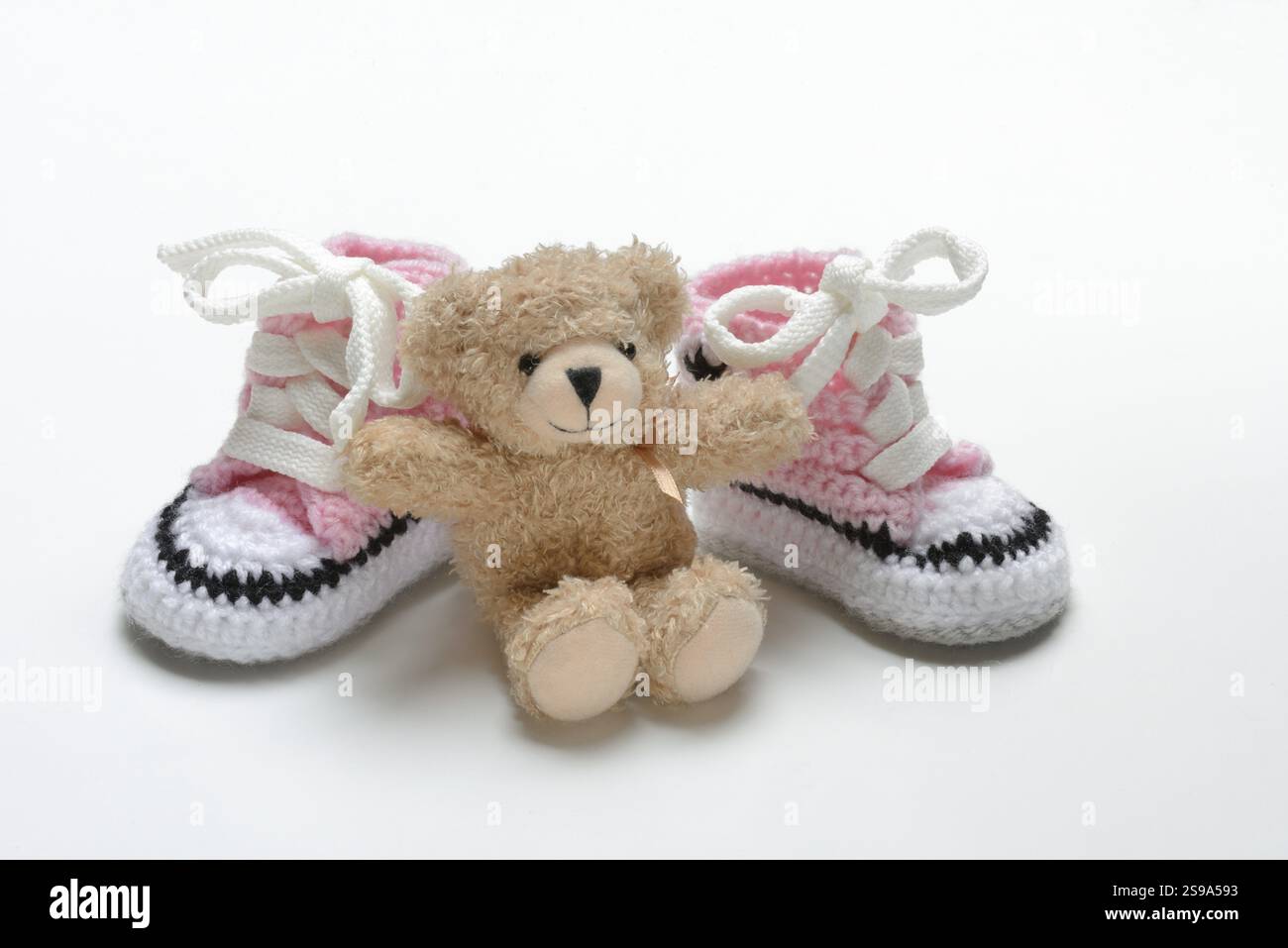 Pinkfarbene Babyschuhe mit Teddybär Stockfoto