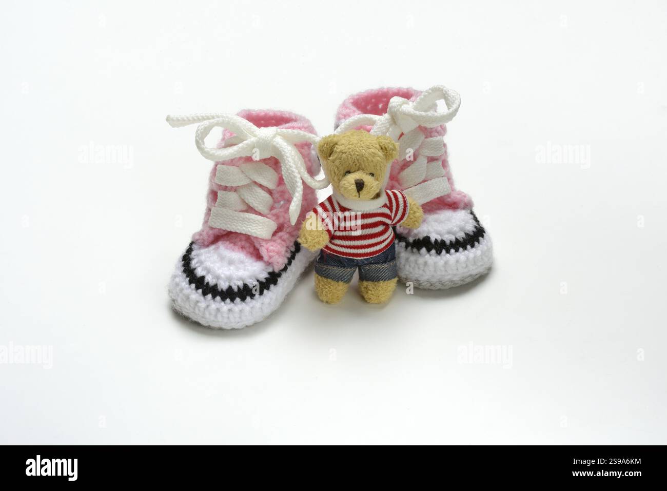 Pinkfarbene Babyschuhe mit Teddybär Stockfoto