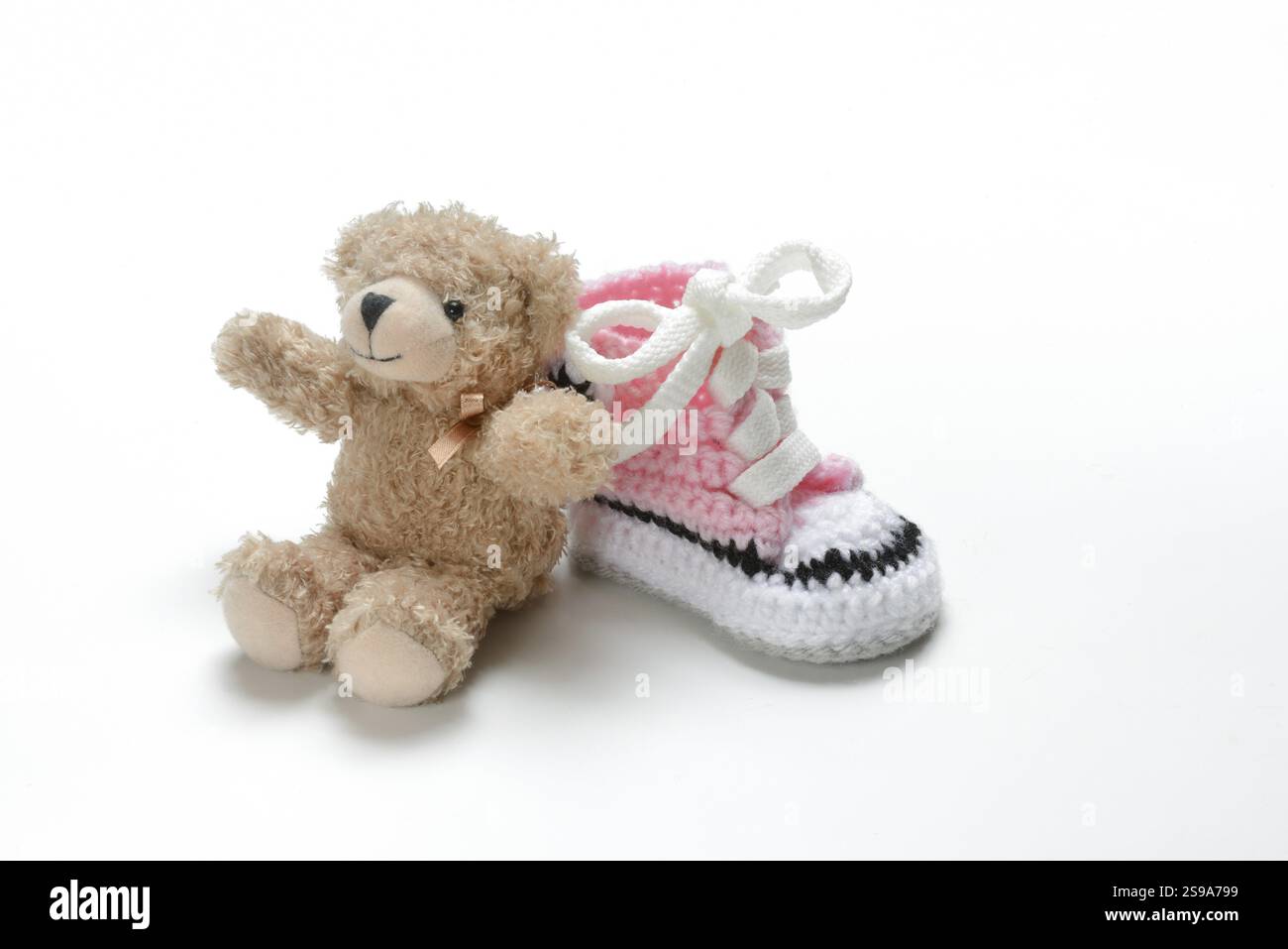 Pinkfarbener Babyschuh mit Teddybär Stockfoto