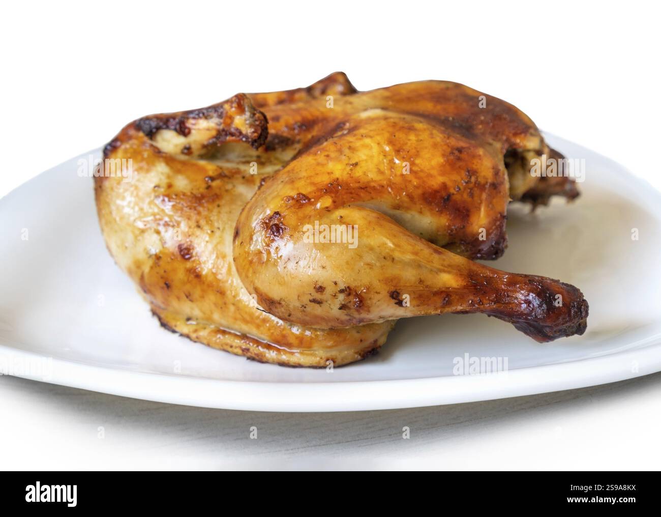 Ganzes goldgeröstetes Hühnchen auf weißem Hintergrund Stockfoto
