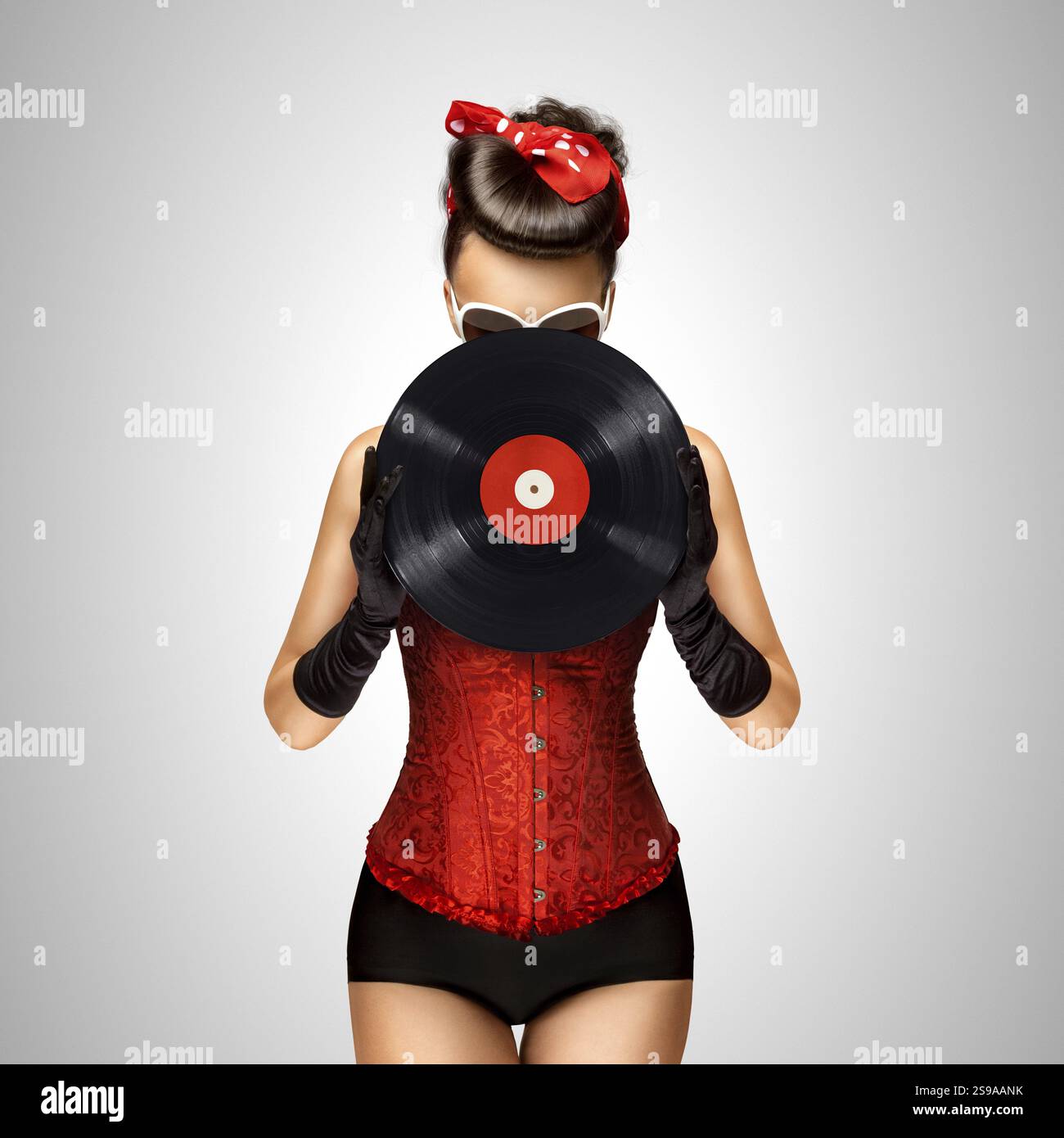 Vintage-Foto eines Pin-up-Modells mit Retro-Aufnahme auf grauem Hintergrund Stockfoto