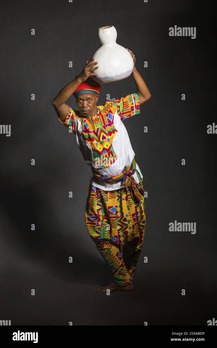 Afrikanischer Mann in traditioneller Kleidung, zahnloses Lächeln, auf grauem Hintergrund Stockfoto