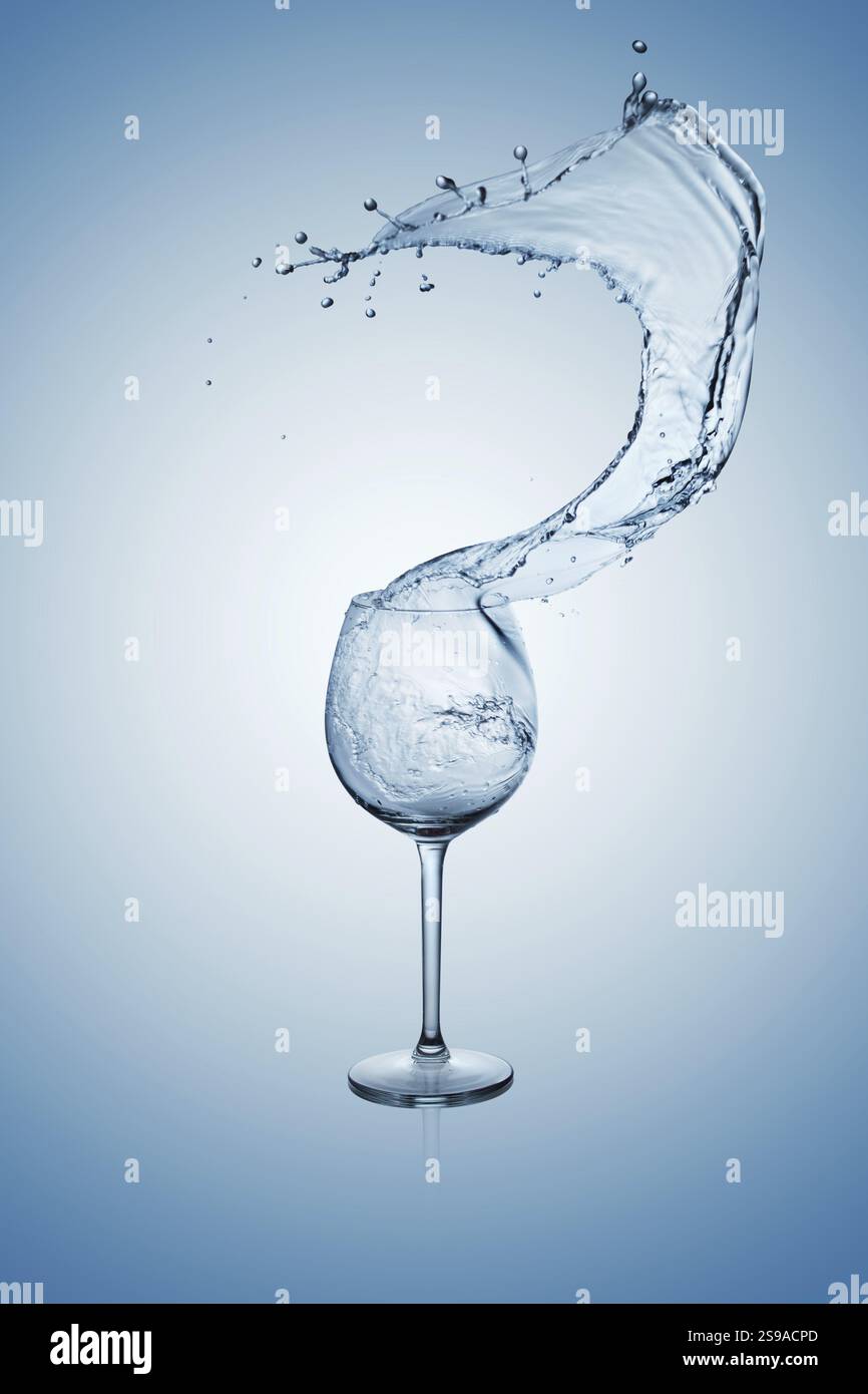 Wasser, das in ein Weinglas mit Stiel spritzt oder aus ihm austritt Stockfoto