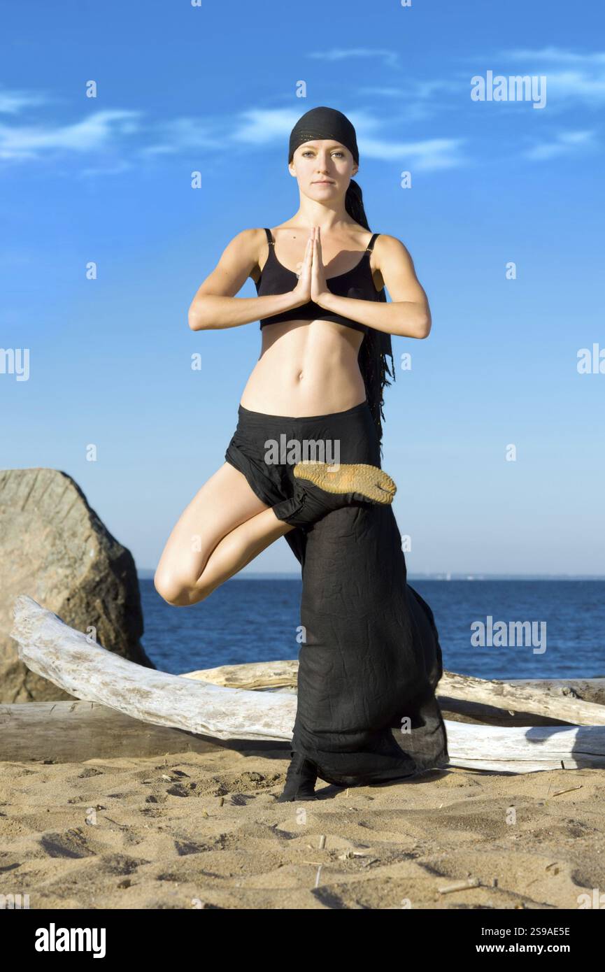 Junge, schöne Frau, die Yoga-Übungen am Strand macht, ST. Petersburg, Russland, Europa Stockfoto