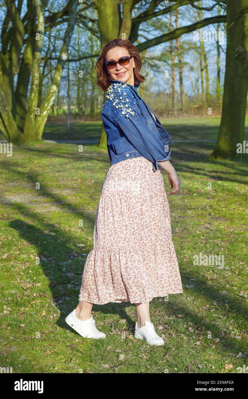 Porträt einer schönen Frau mittleren Alters, die im Park posiert Stockfoto