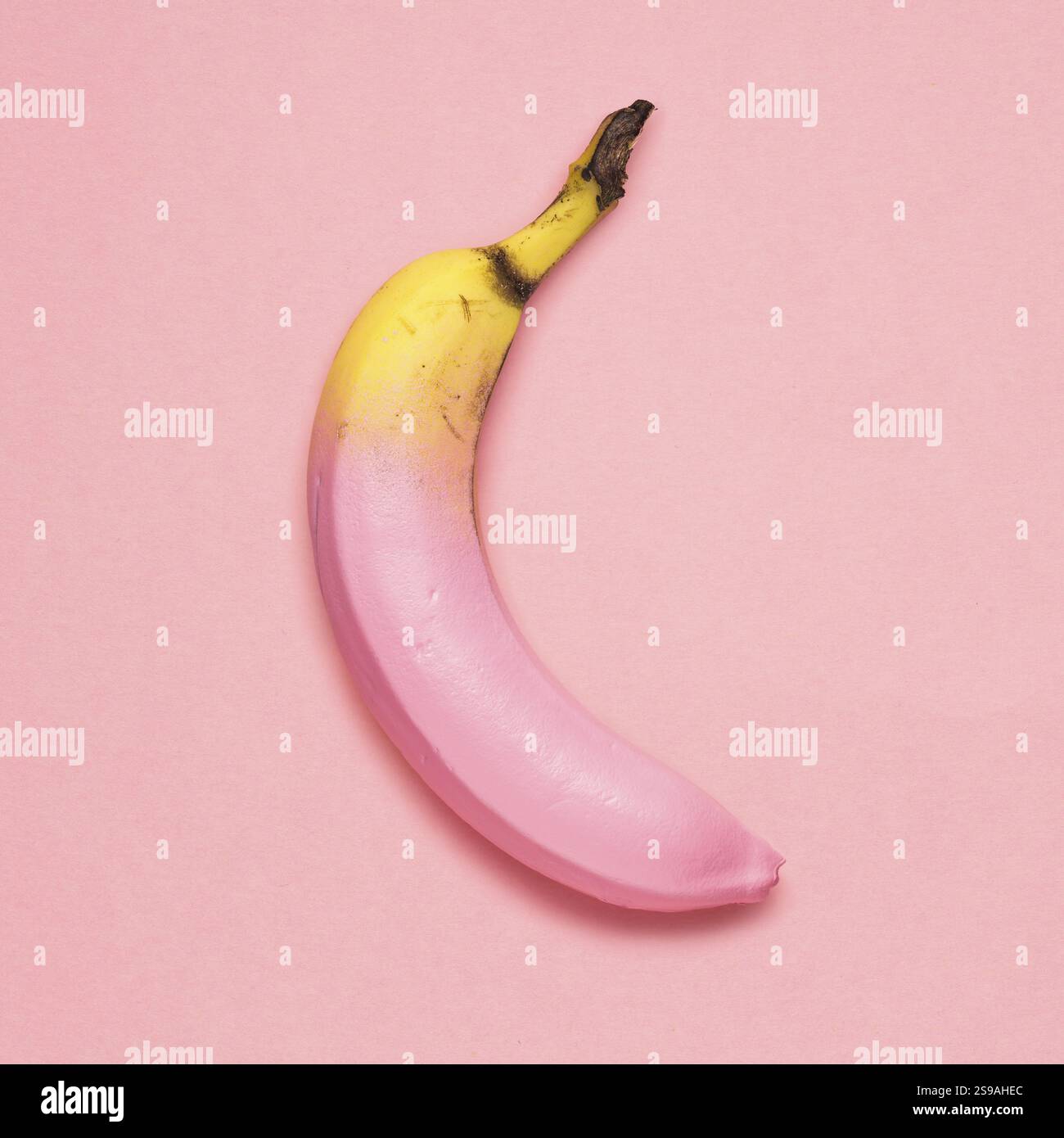Kreatives Foto einer bemalten Banane auf rosa Hintergrund Stockfoto