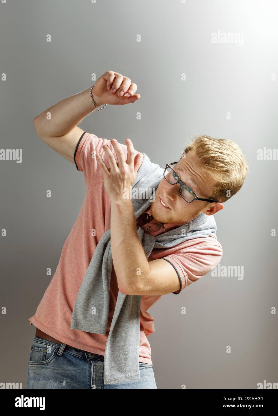 Hübscher junger blonder Mann auf grauem Hintergrund Stockfoto