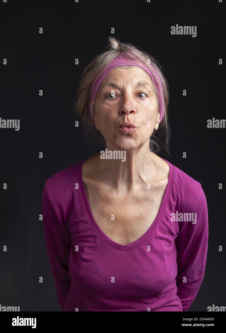 Glückliche lächelnde reife Frau in ihrer 75-jährigen Dame mit trendigen weißen kurzen Haaren Stockfoto