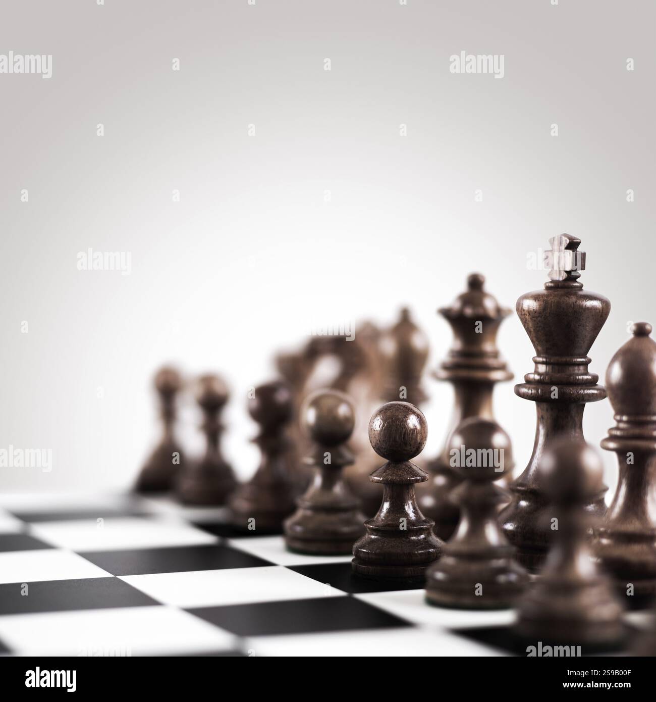 Strategie- und Taktikkonzept, schwarze Holzfiguren auf dem Brett stehen in einer Reihe bereit für das Spiel Stockfoto