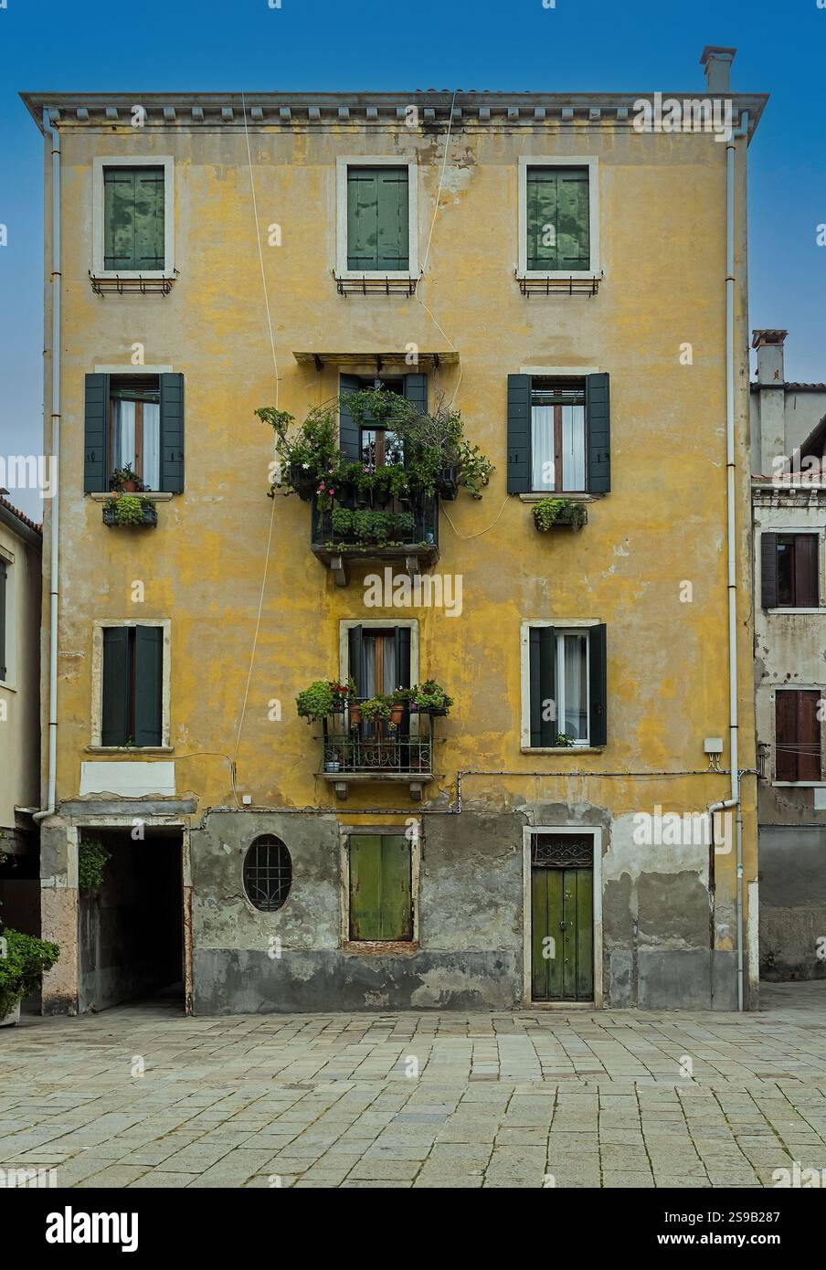 Altes mittelalterliches Haus in Venedig mit geschlossenen Fenstern und Balkonen Stockfoto