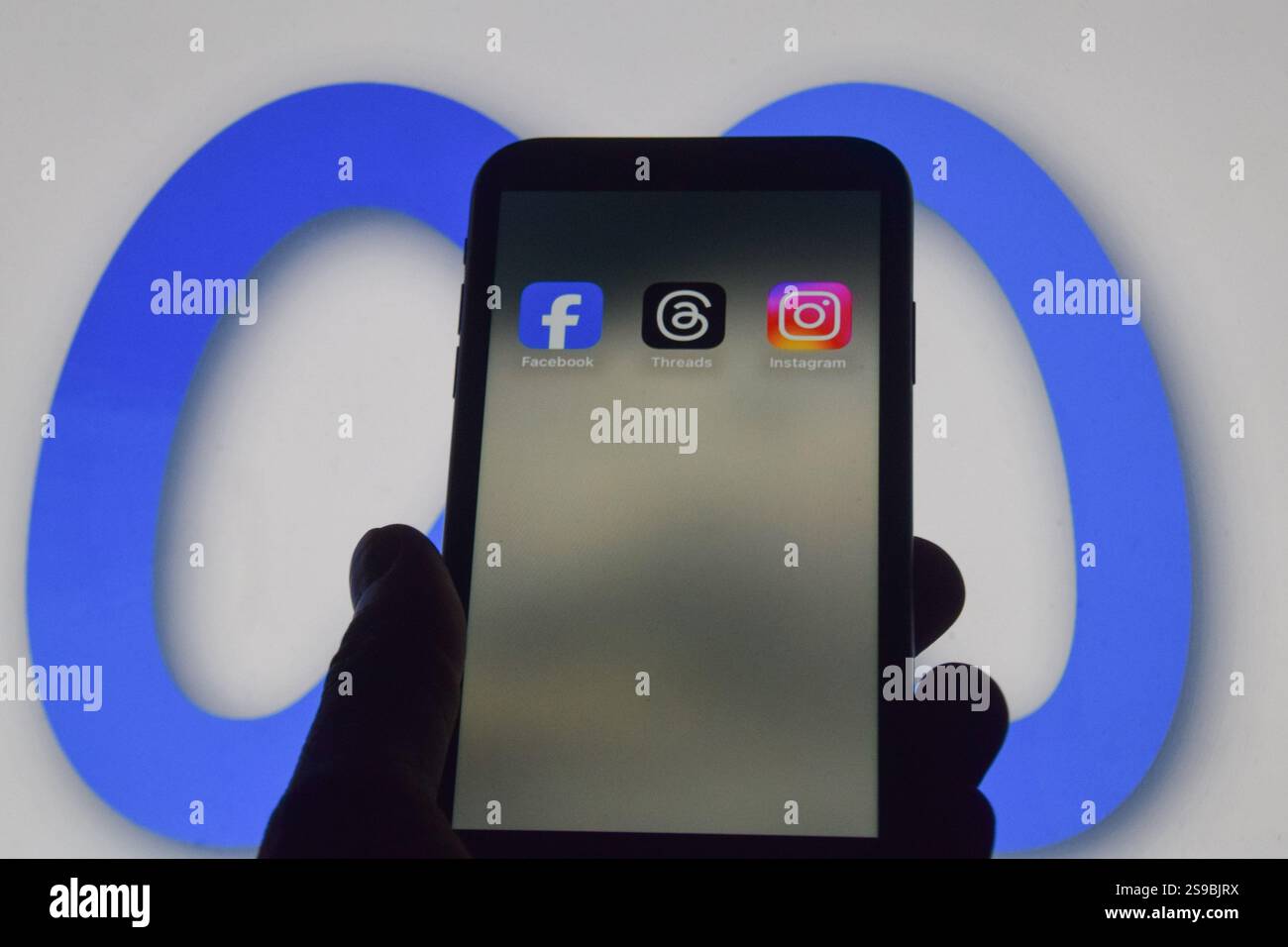 London, Großbritannien. Januar 2025. Facebook-, Threads- und Instagram-Apps auf einem Telefonbildschirm und das Meta-Logo im Hintergrund, als Meta-Gründer Mark Zuckerberg ankündigt, dass der Social-Media-Gigant die Zensur reduzieren wird, mehr politische Inhalte empfehlen und Faktenüberprüfungen in seinen Apps entfernen wird und sie durch „Community Notes like like X“ ersetzt. Quelle: Vuk Valcic/Alamy Stockfoto