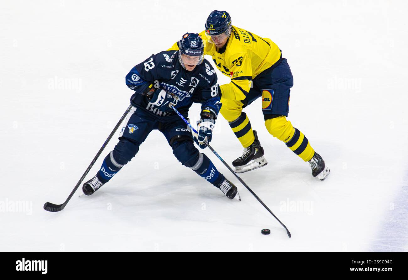 Fribourg, Schweiz, 14. Dezember 2024: Stürmer #82 Harris Pesonen (Finnland) muss den Puck gegen Verteidiger #73 Adam Ollas Mattsson (Schweden) verteidigen. Stockfoto Fribourg, Schweiz, 14. Dezember 2024: Stürmer #82 Harris Pesonen (Finnland) muss den Puck gegen Verteidiger #73 Adam Ollas Mattsson (Schweden) verteidigen. Stockfoto